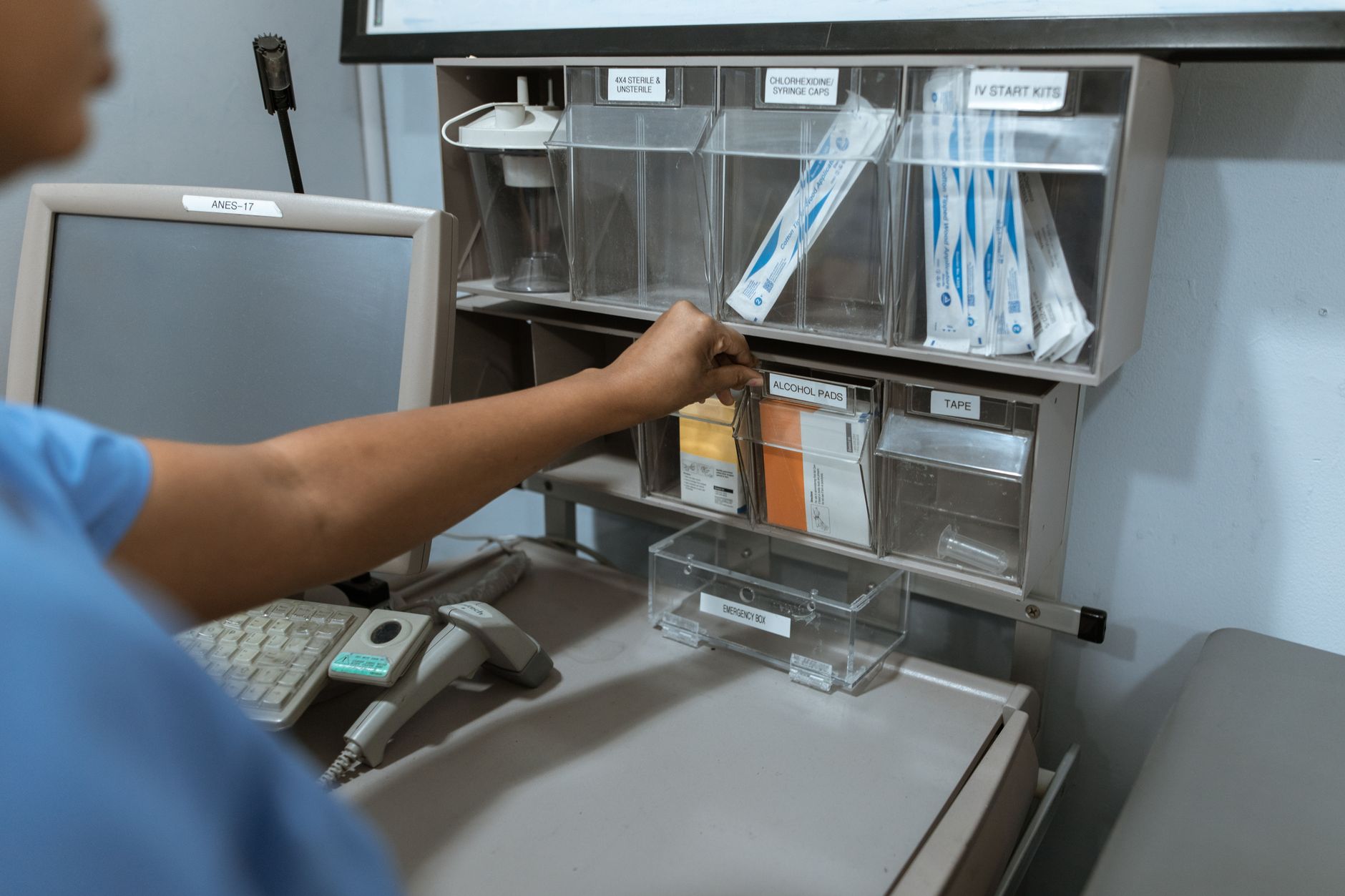 Clinic staff taking supplies from a stocked cabinet