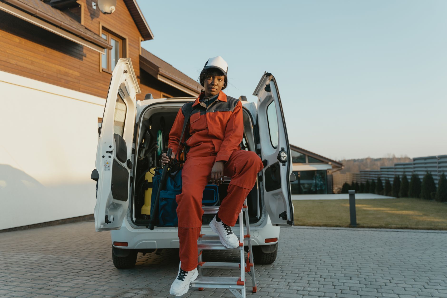 Service technician unloading tools from a van outside a home