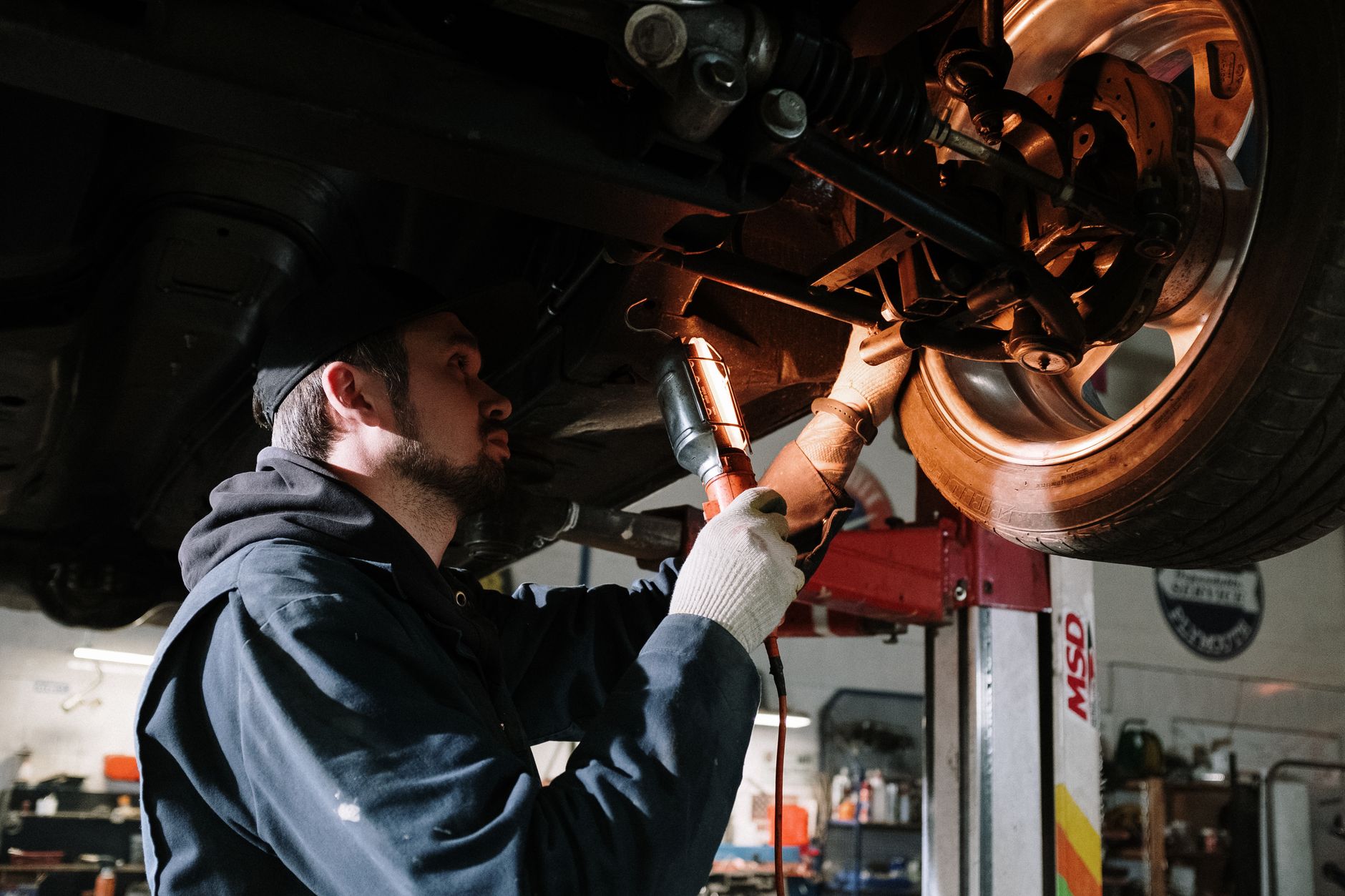 Mechanic working under a car on a lift