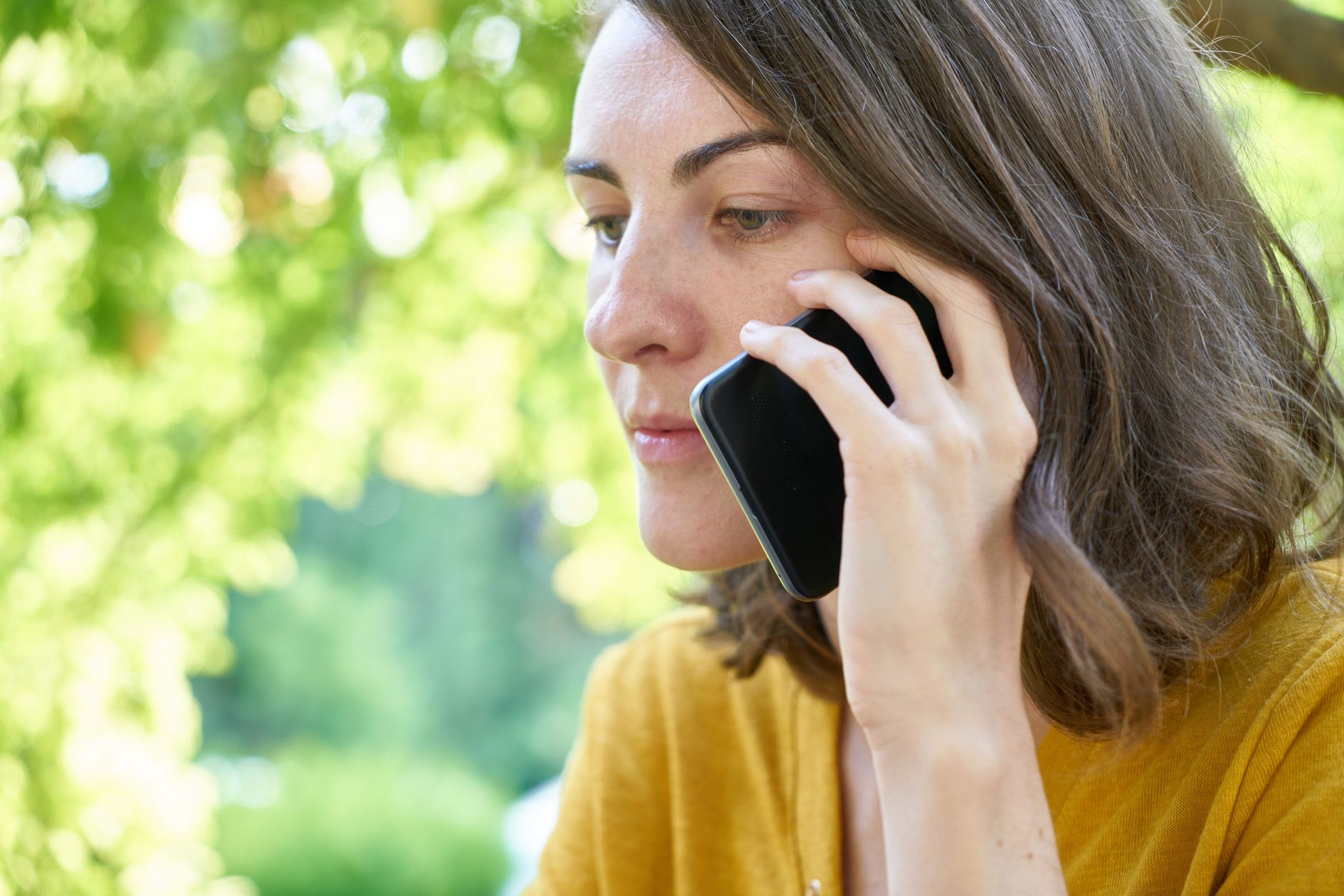 Woman answering a follow-up call outdoors