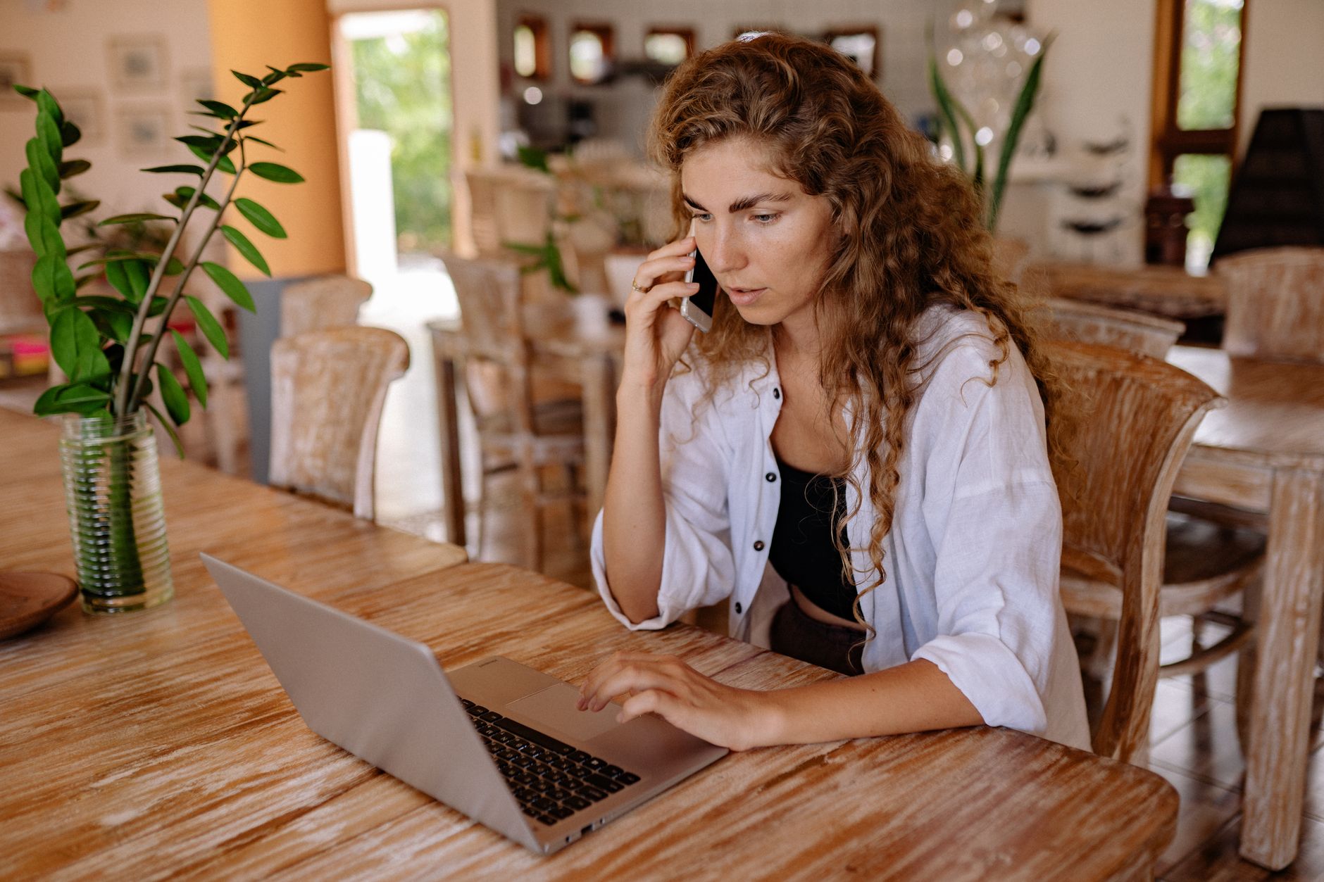 Woman on a phone call at home with a laptop