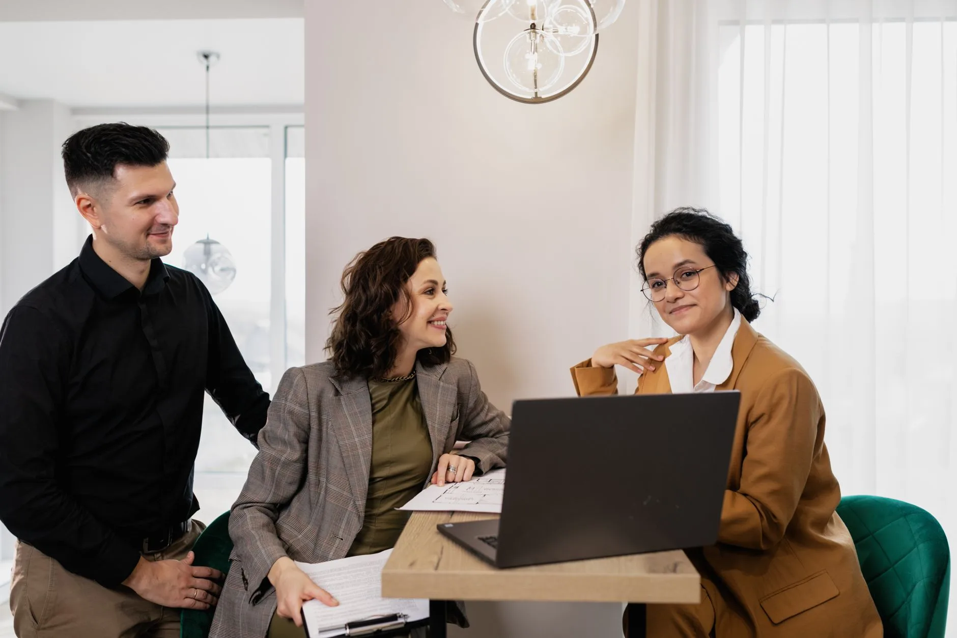 Consultant walking two clients through results on a laptop