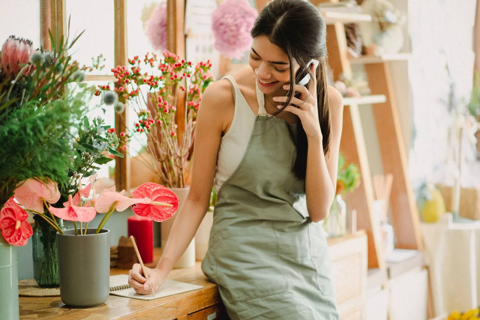 Florist taking a customer call on her phone in her flower shop