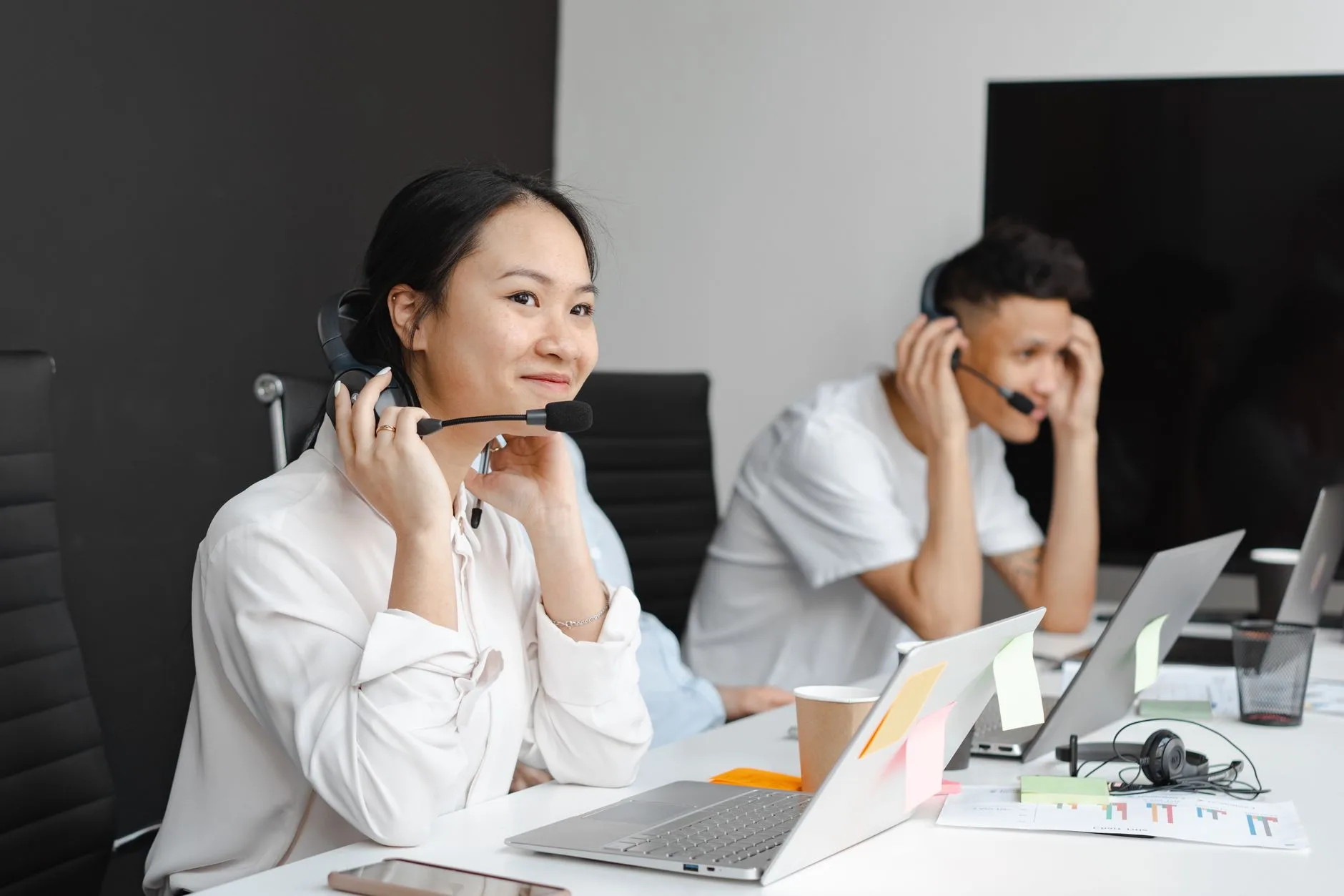 Three support colleagues smiling, two of them wearing headsets