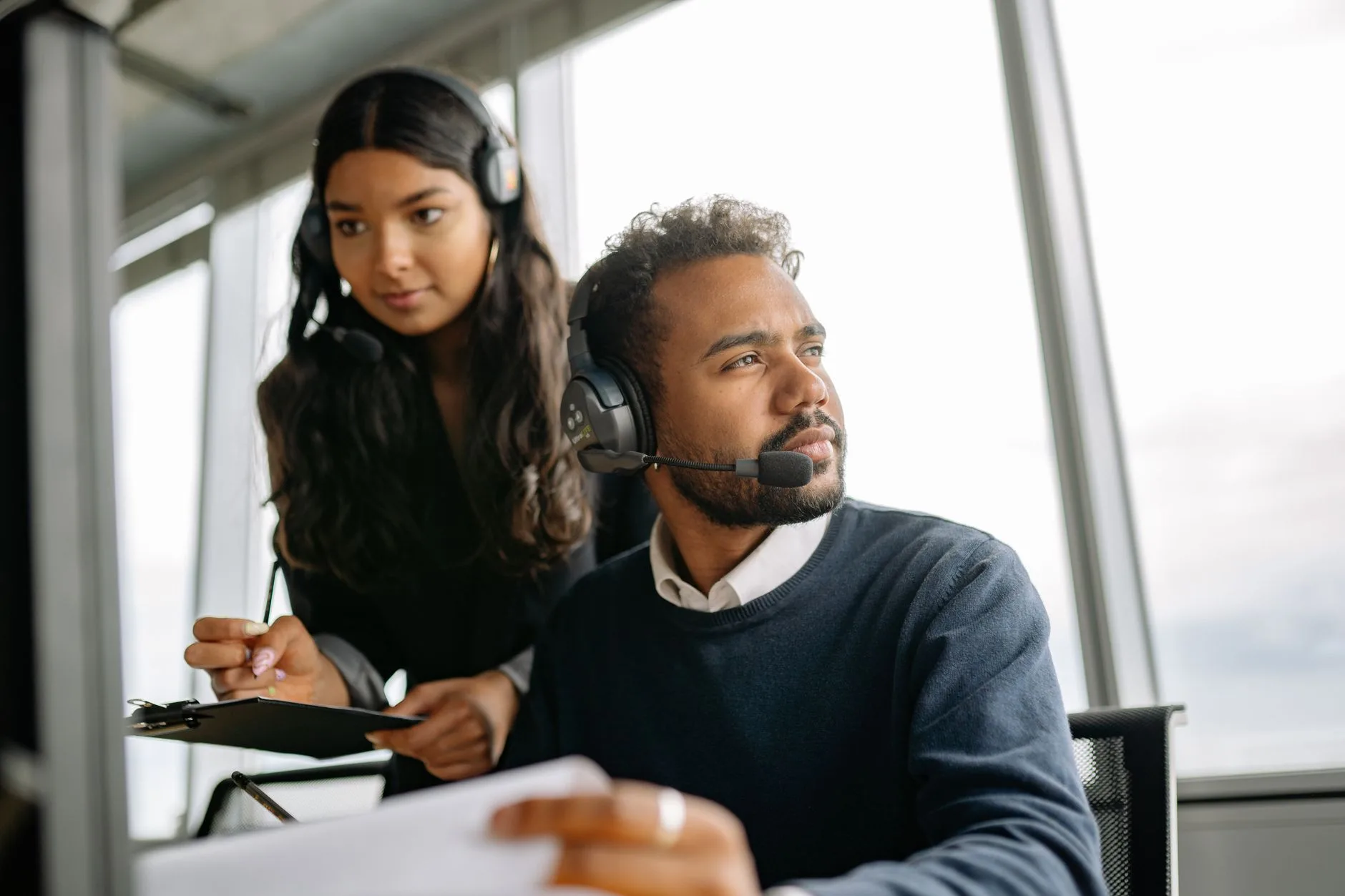 Support agent wearing a headset reviewing a case with a colleague