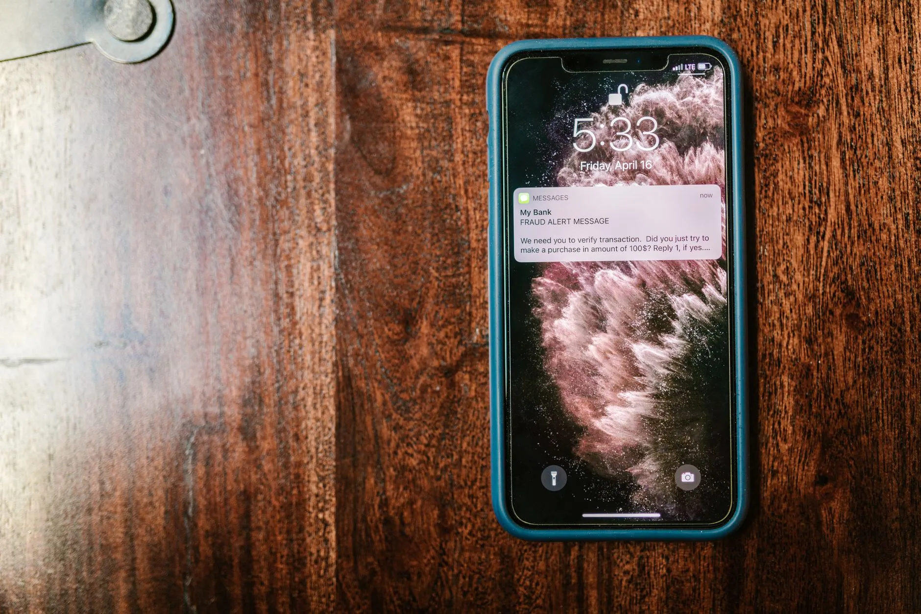 Smartphone on a wooden table showing a notification on its lock screen