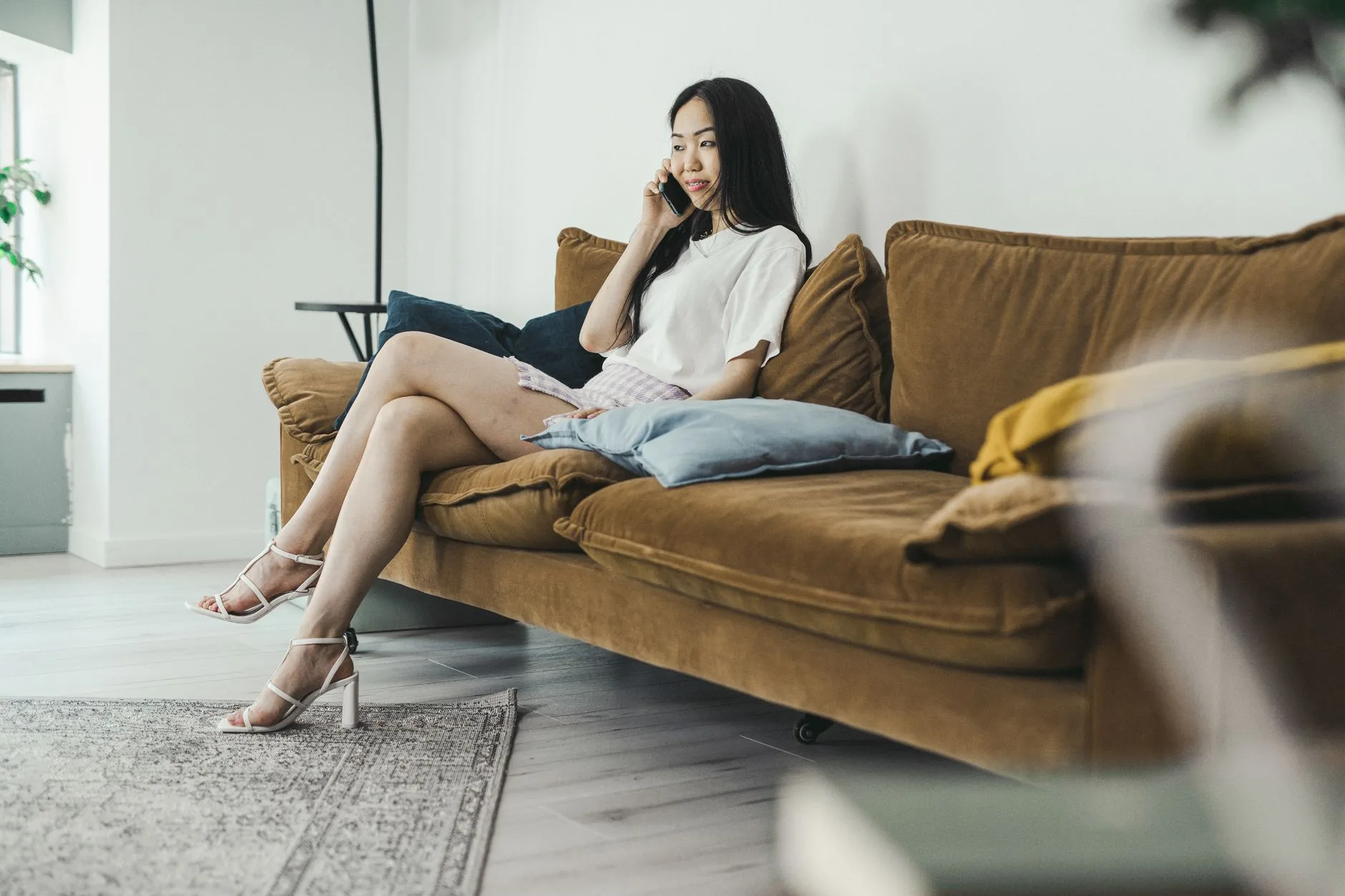 Woman on a phone call sitting on a sofa at home
