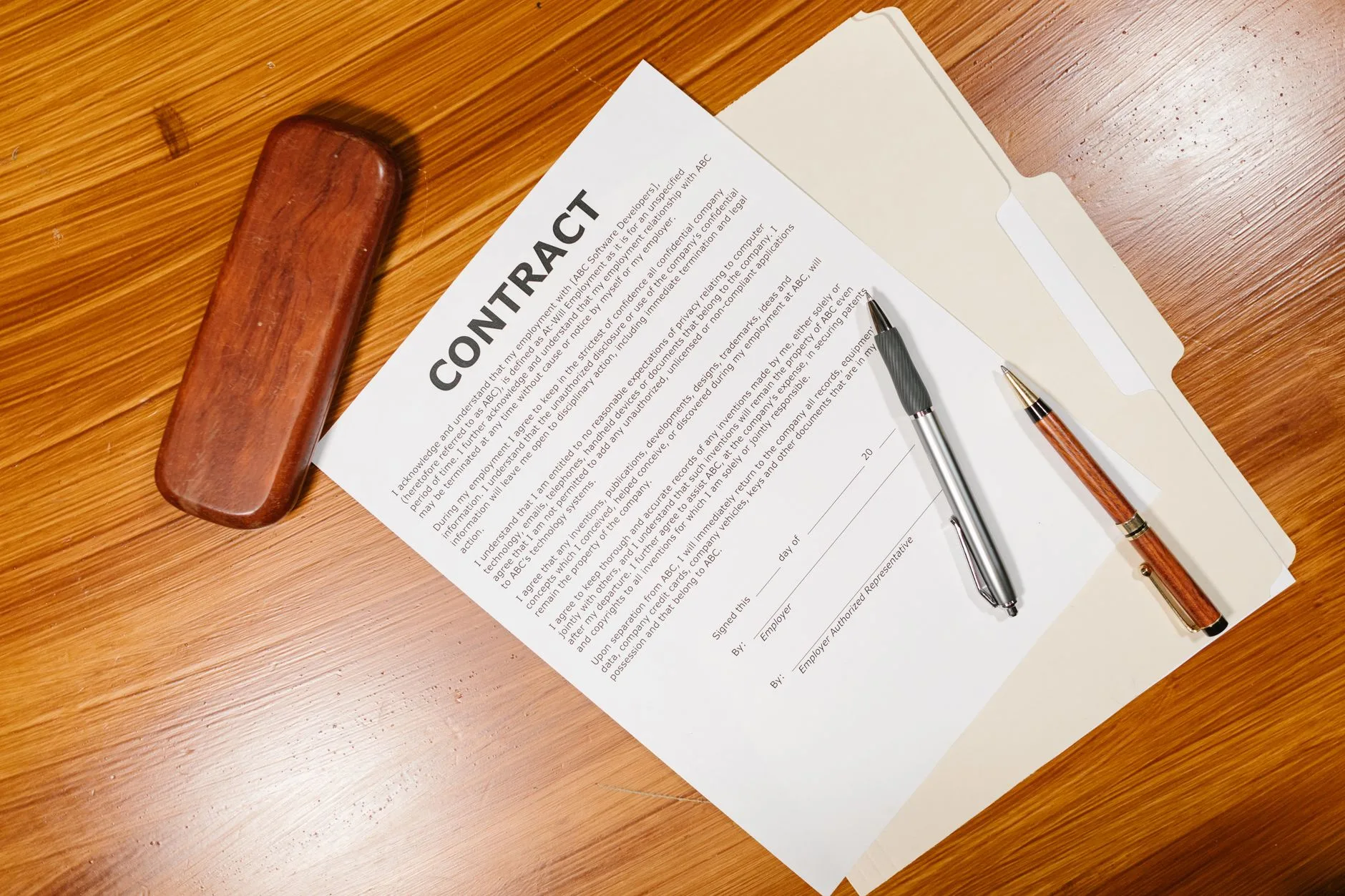 Printed contract on a desk with a pen on top
