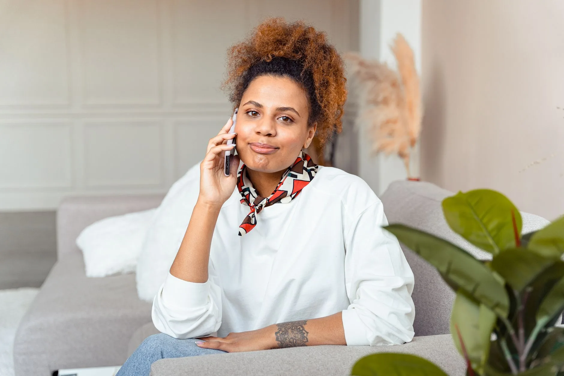 Woman on the sofa at home taking a phone call