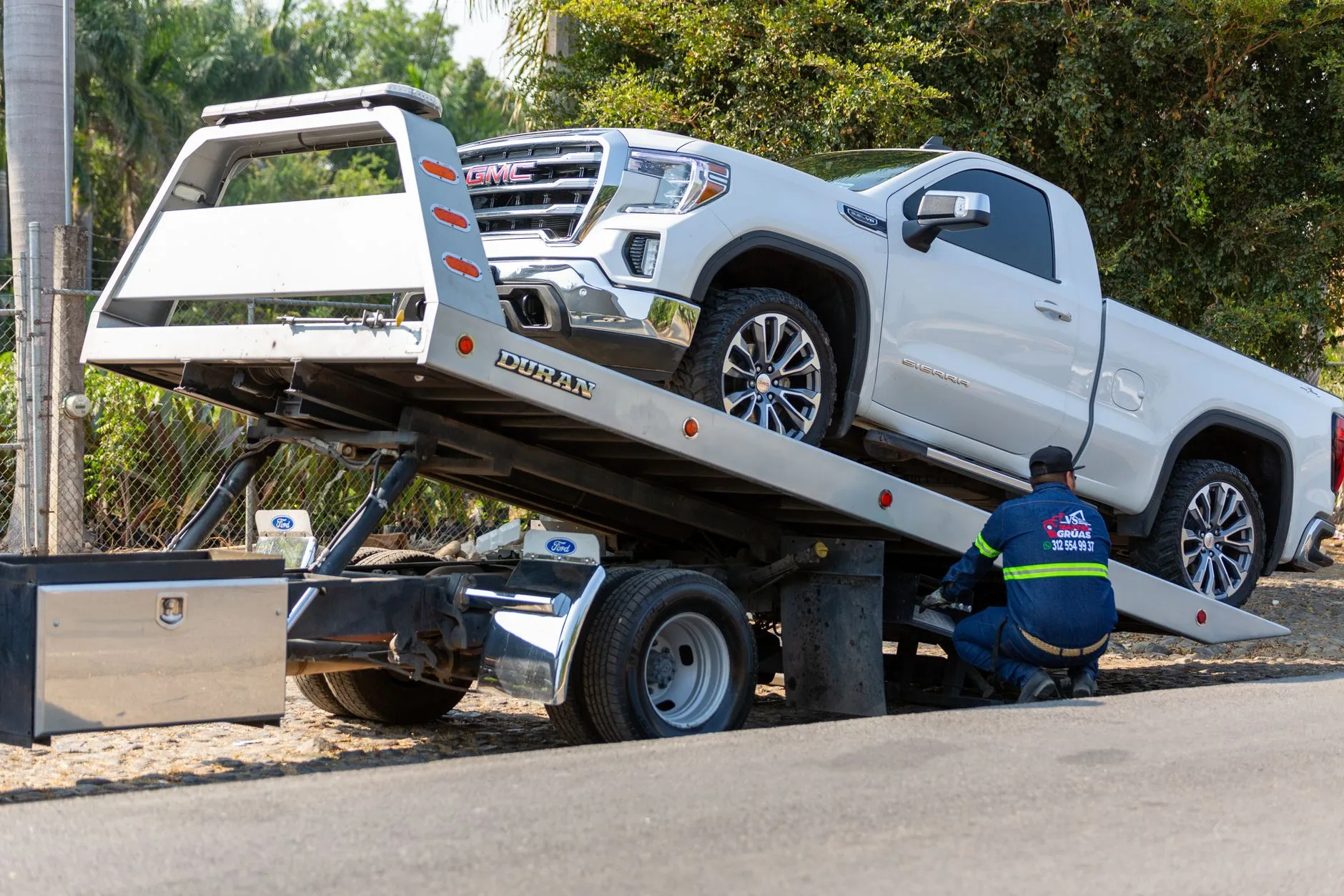 Tow operator loading a pickup truck onto a flatbed