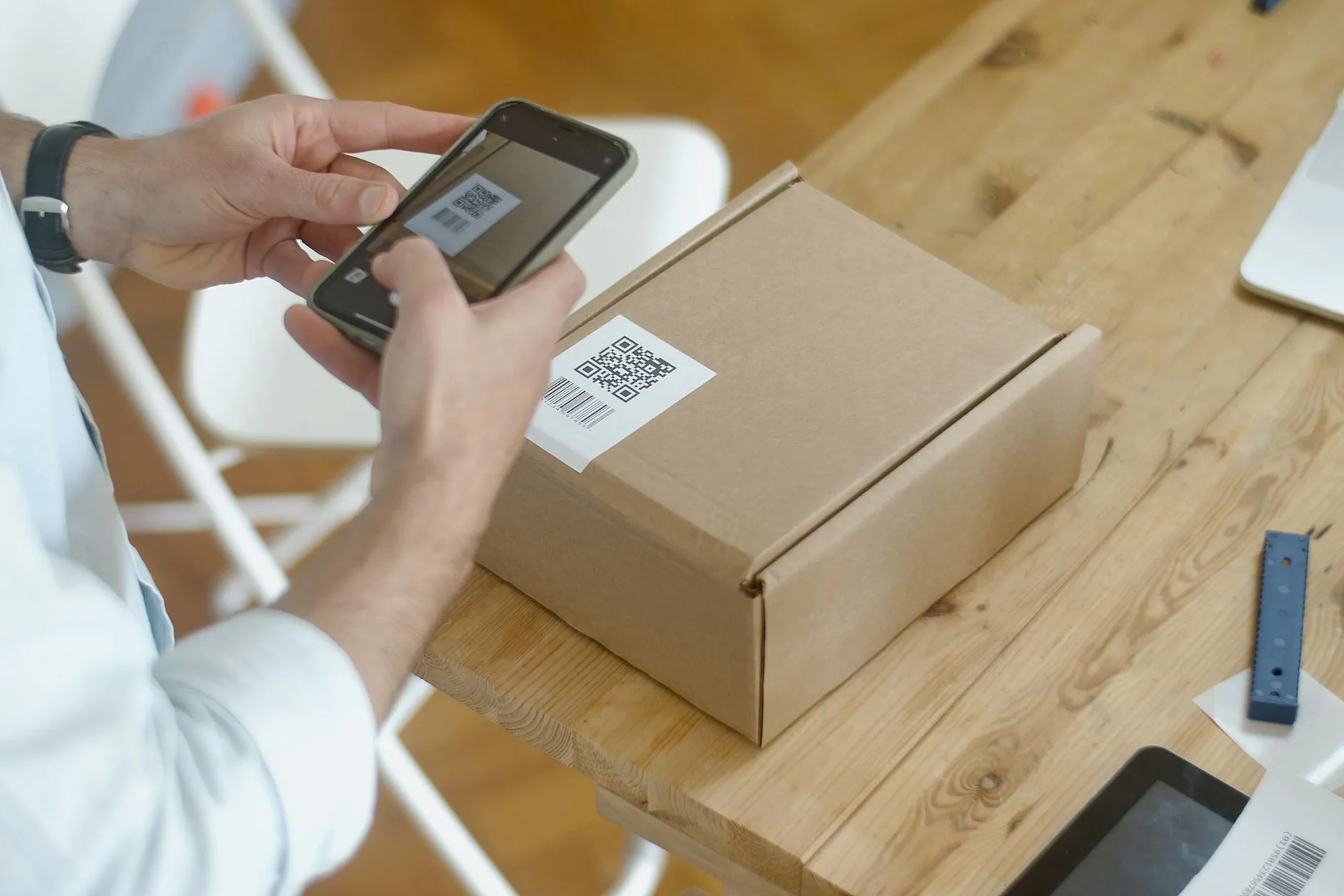 Person using a smartphone camera on a labeled package