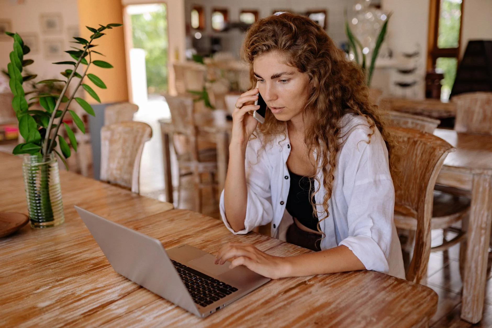 Woman on a phone call while working on her laptop