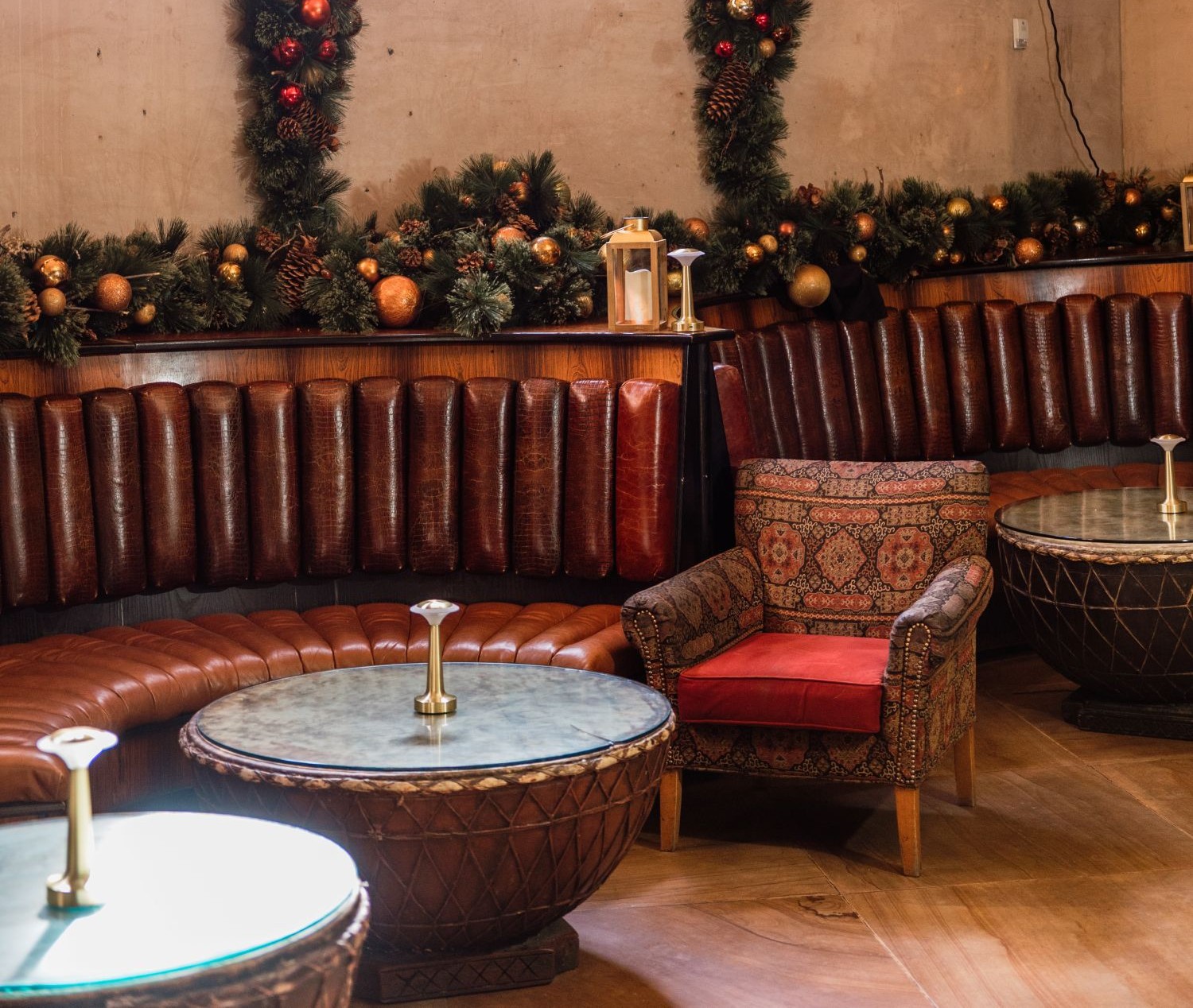 Leather booth like seating with upholstered chairs with decorated Christmas garlands