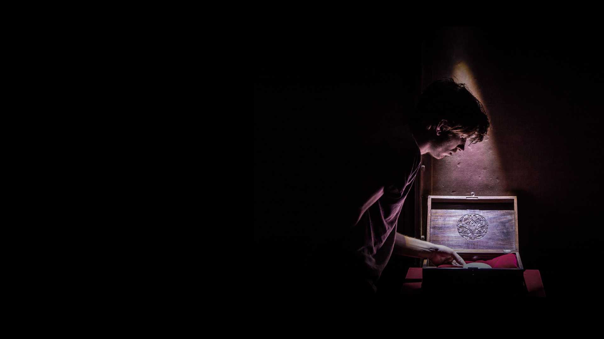 a person opening a mysterious box in a dimly lit room