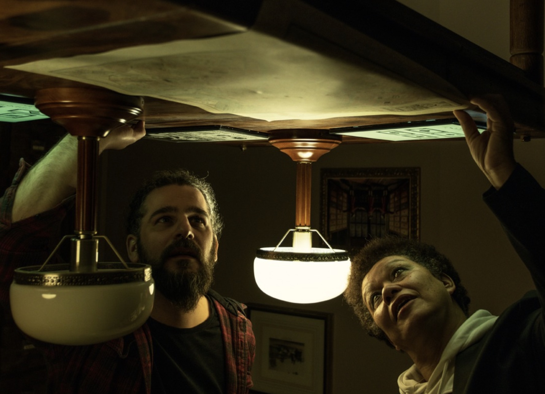 Players examining the underside of a table in the upside down room