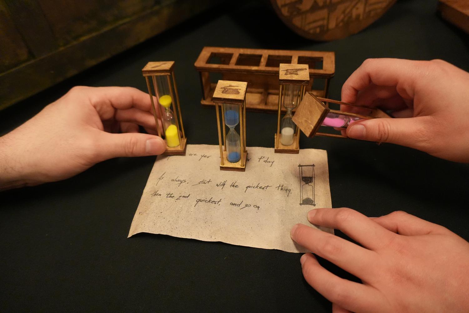 Small coloured hourglasses arranged on a handwritten note