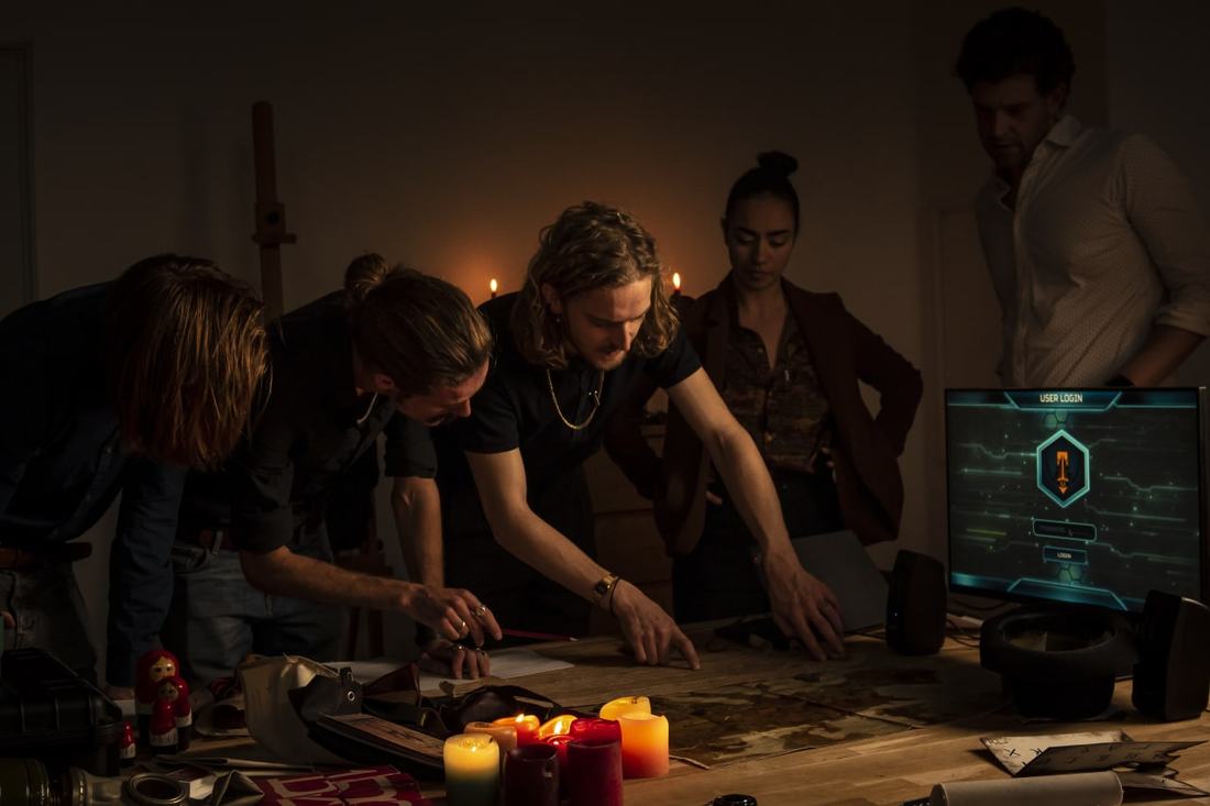 A team working by candlelight around a table of objects