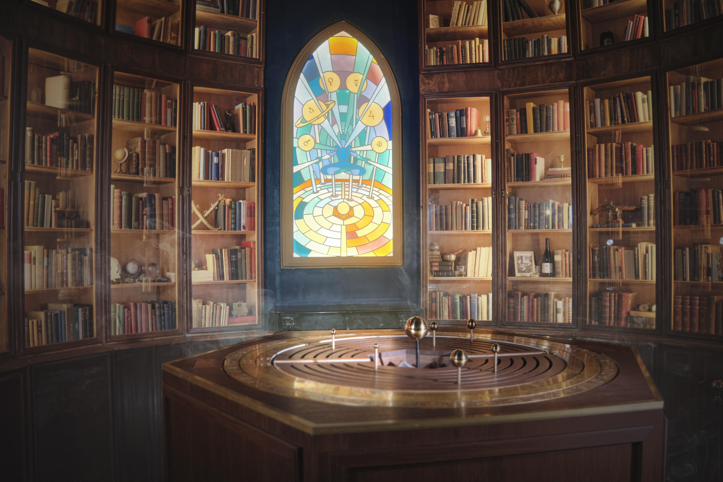 an alchemist's altar with a colorful window and bookshelves