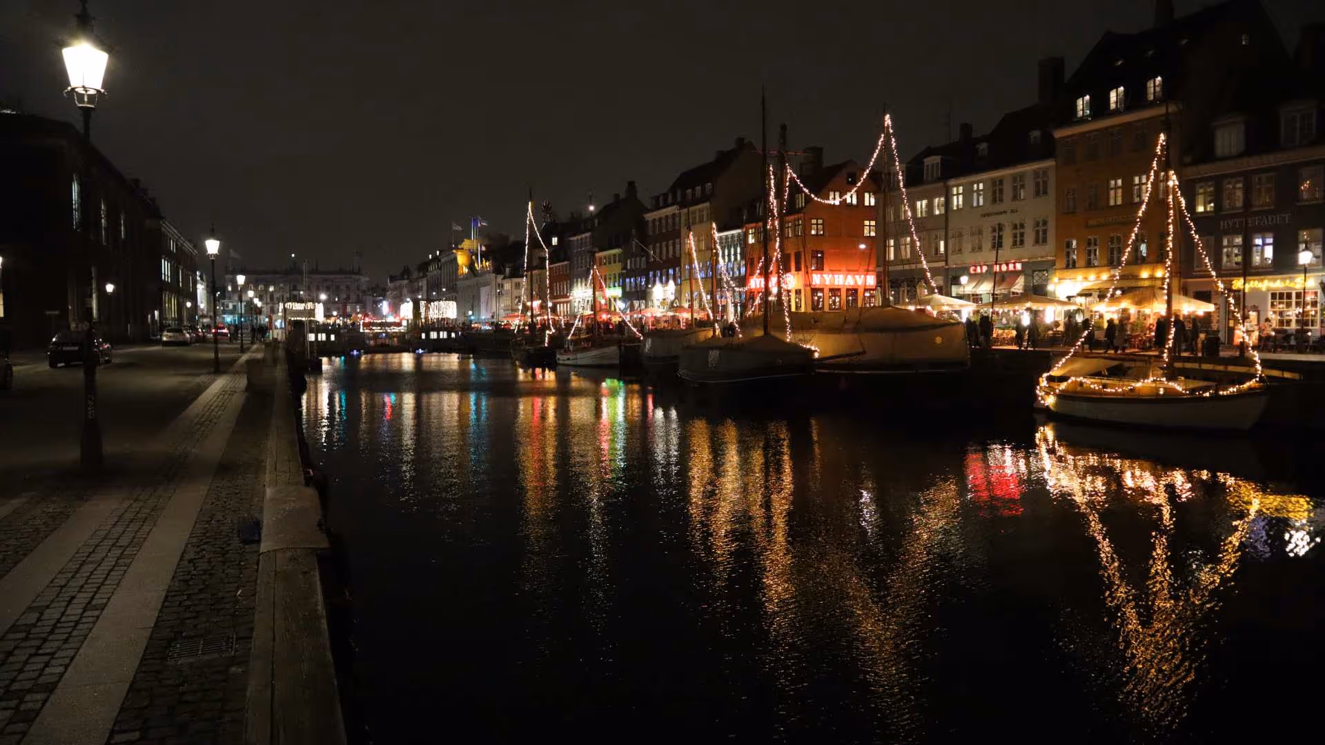 Scenic night view of Amsterdam canals illuminated by festive lights during a private local-led city boat tour.