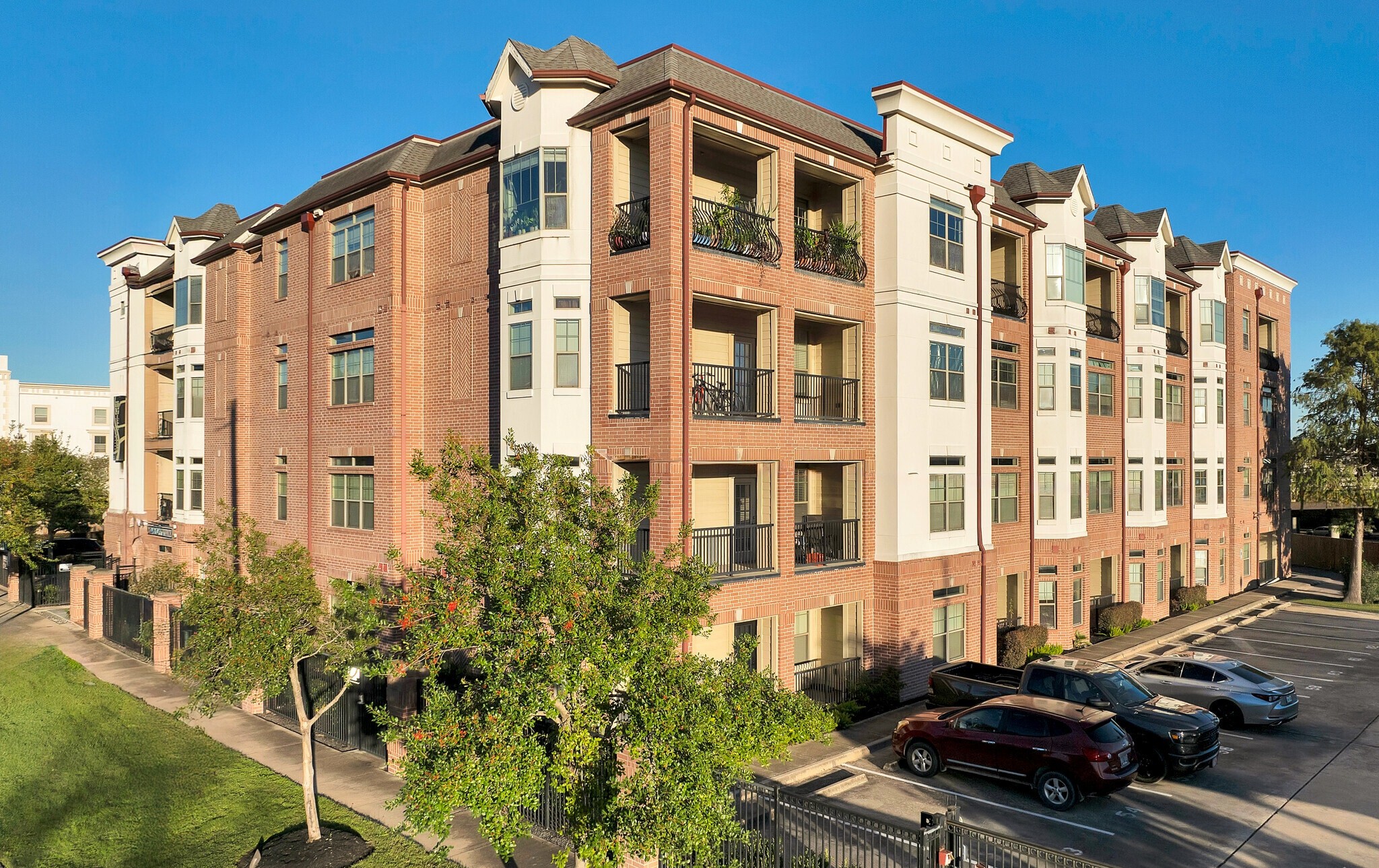 Aerial view of multi-story brick and stone buildings with trees along the street in an urban area.