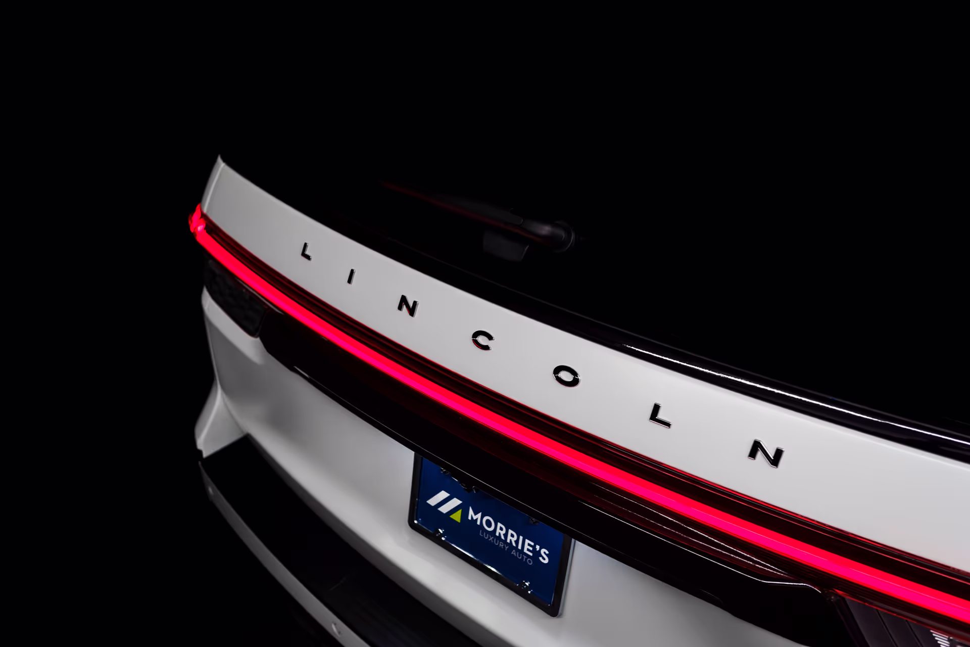 rear of white lincoln car with logo