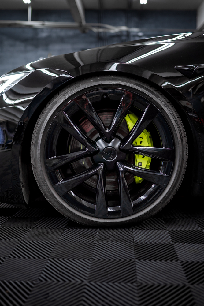Black wheel and yellow brake caliper on a Tesla Model S