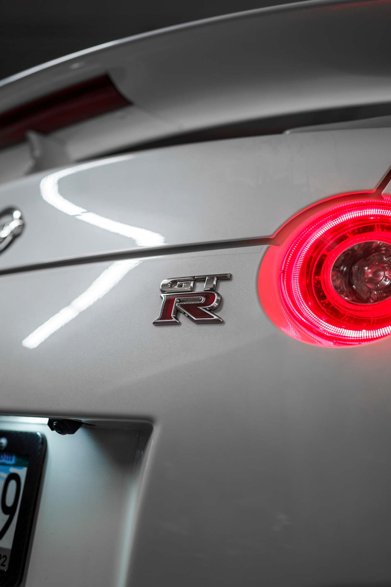 GT-R badge and taillight on the rear of the white Nissan