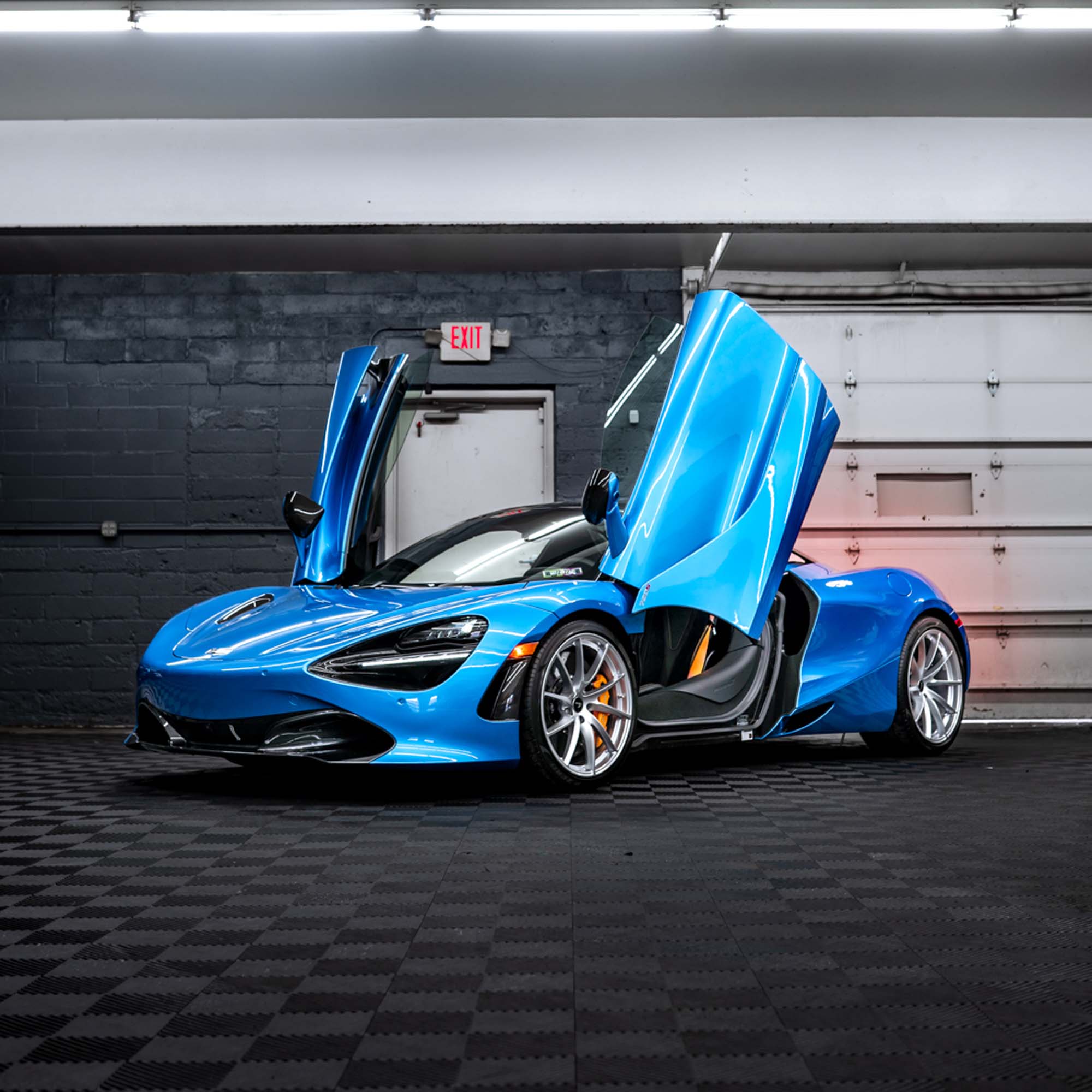 Blue McLaren 720S with both dihedral doors open