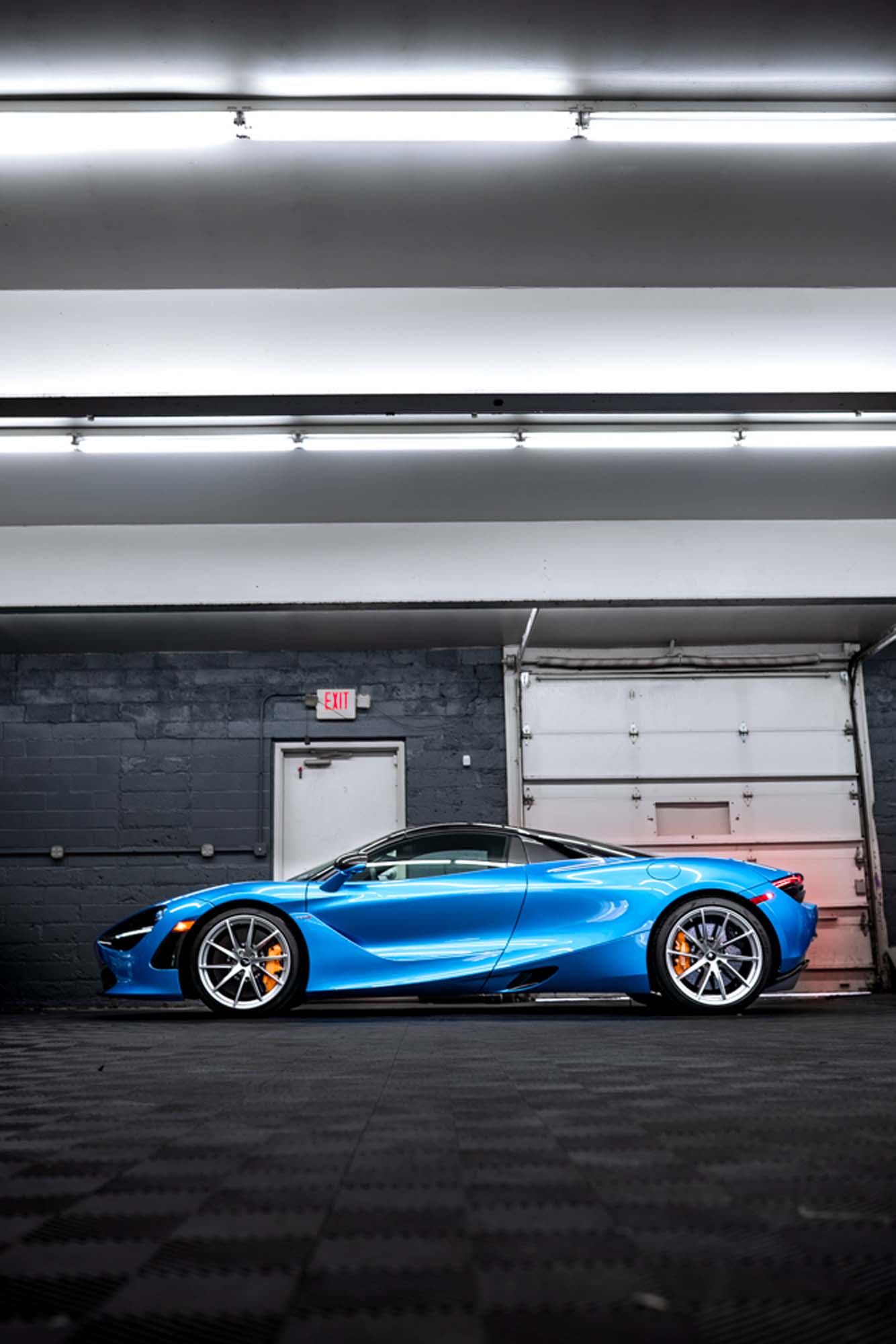 Side profile of the blue McLaren 720S in the studio