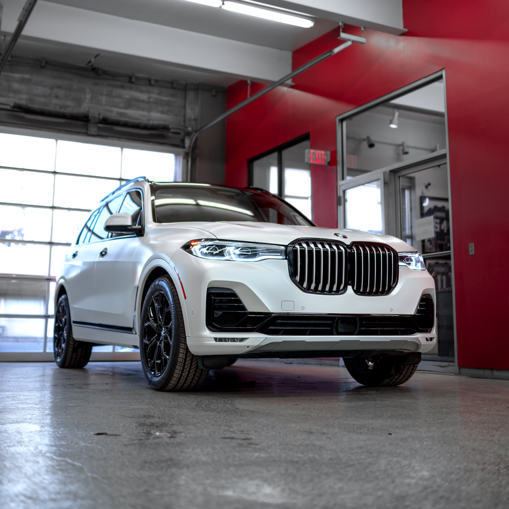 Front three-quarter view of the white BMW X7 in the shop