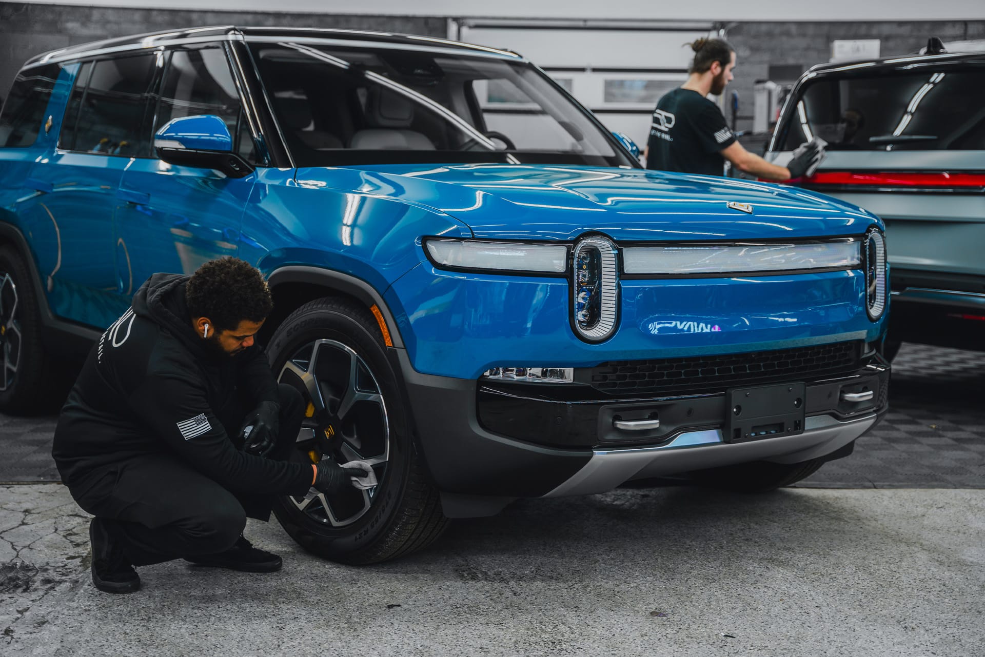 Installer working on a blue Rivian R1S at Pristine Detail