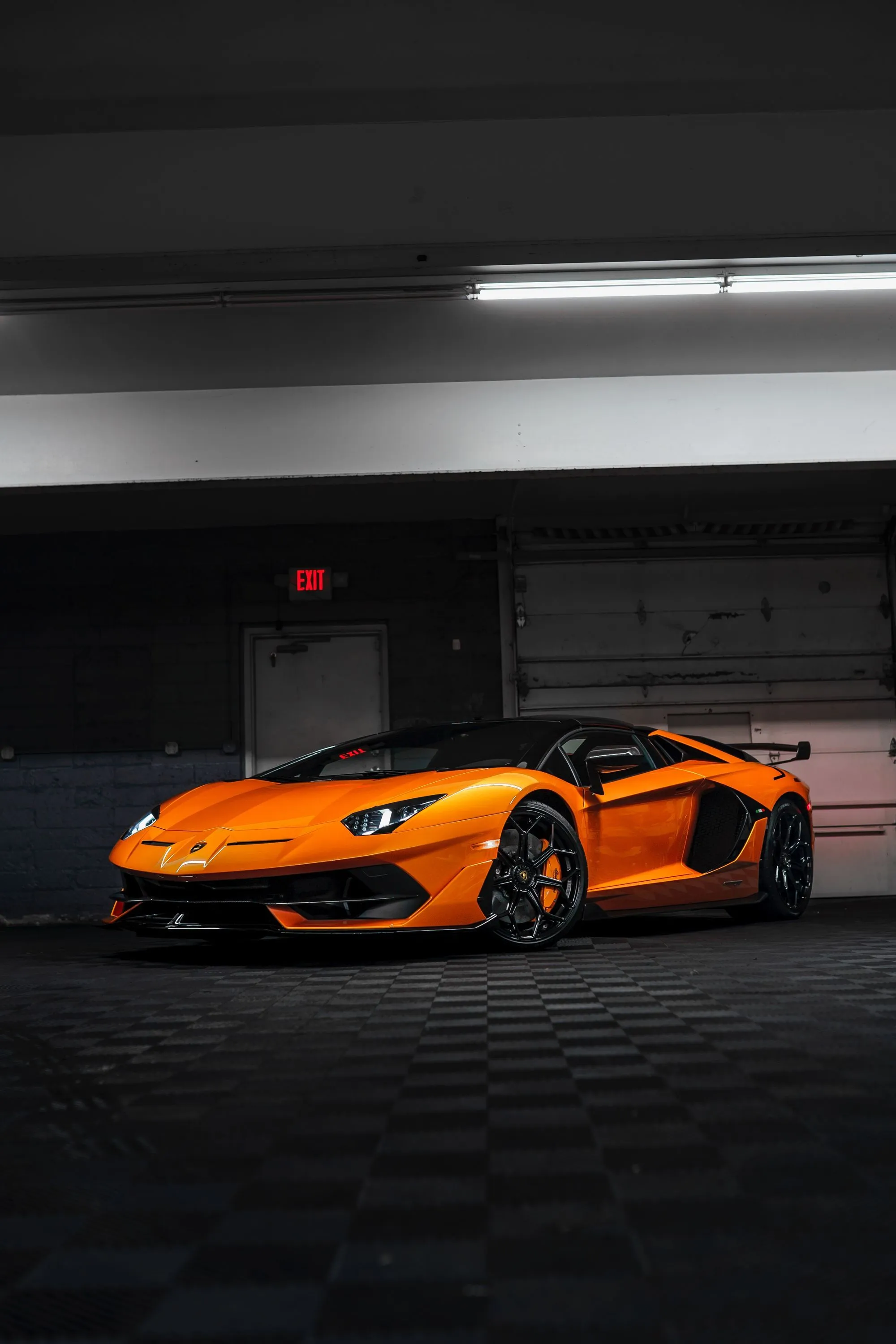 An orange Lamborghini Aventador parked inside a garage