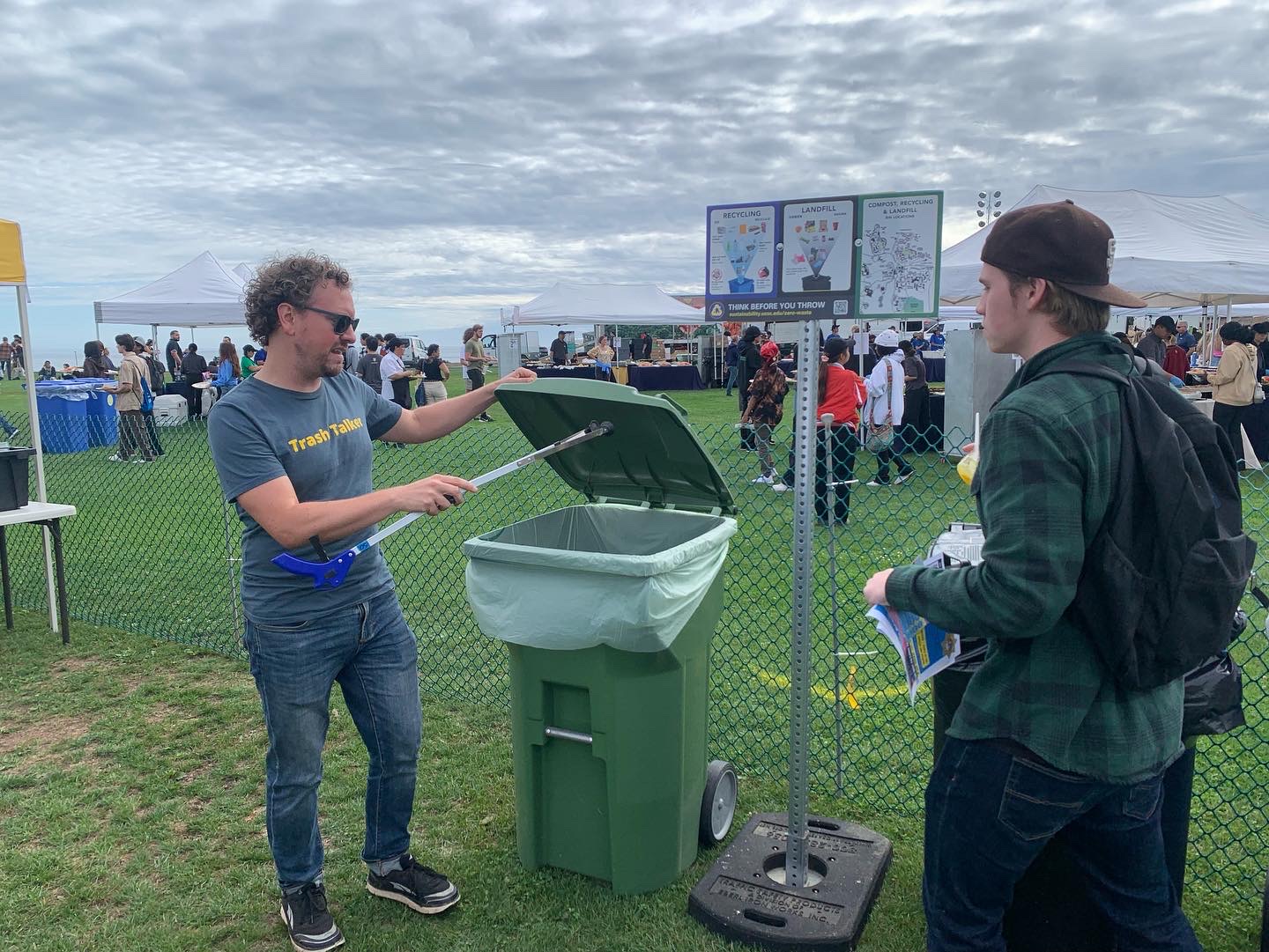 A large group of students with handheld bins and waste pickers.
