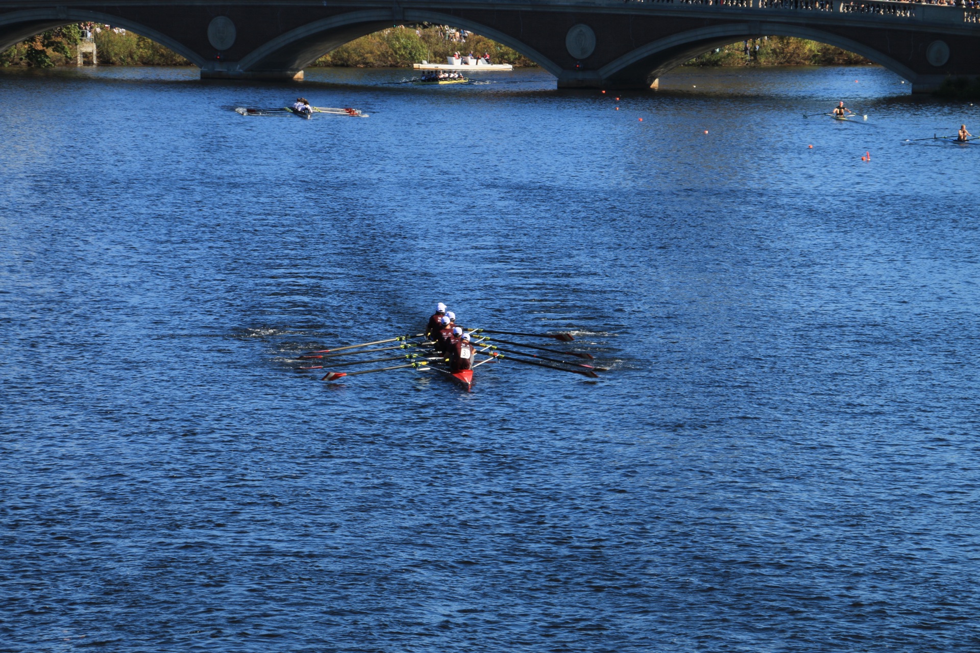 A rowing eight comes out from under the Weeks Footbridge on the Charles River during the Head of the Charles Regatta