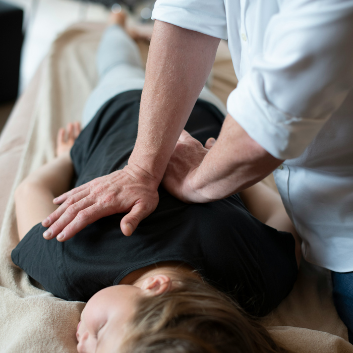 chiropractor performing treatment on girl's back