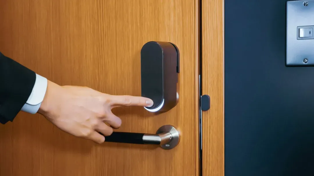 Photo of a man touching the bitlock pro smart lock attached to a wooden door
