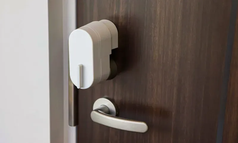 A white bitlock MINI attached to a dark wooden door