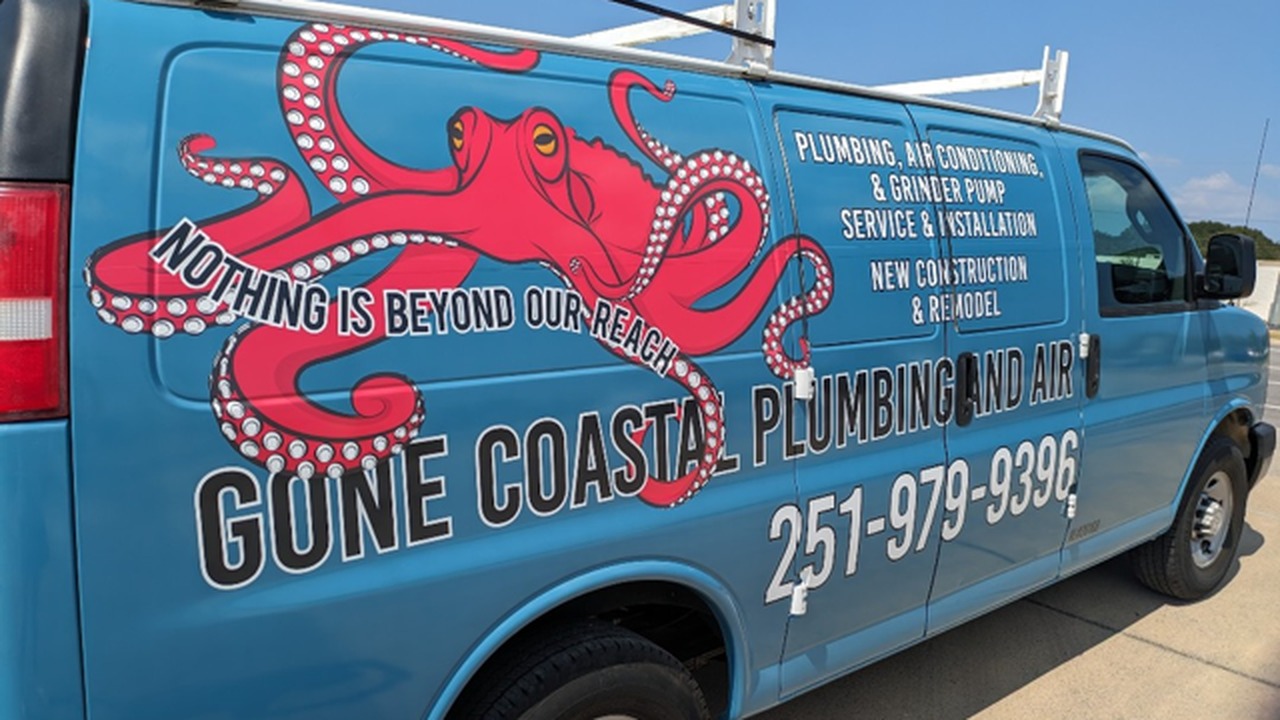 Technician inspecting an outdoor HVAC unit at a coastal Orange Beach home