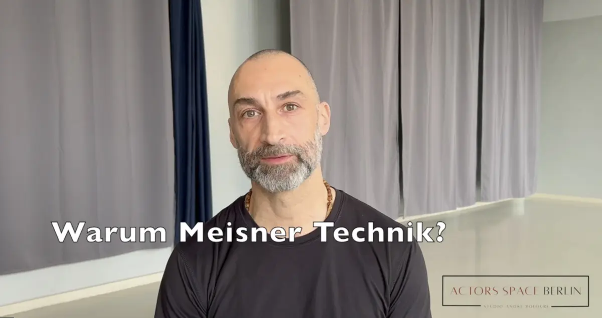 Ein Mann mit grauem Bart und dunklem Shirt sitzt in einem Studio vor grauen Vorhängen. Über dem Bild steht der Text: „Warum Meisner Technik?“.