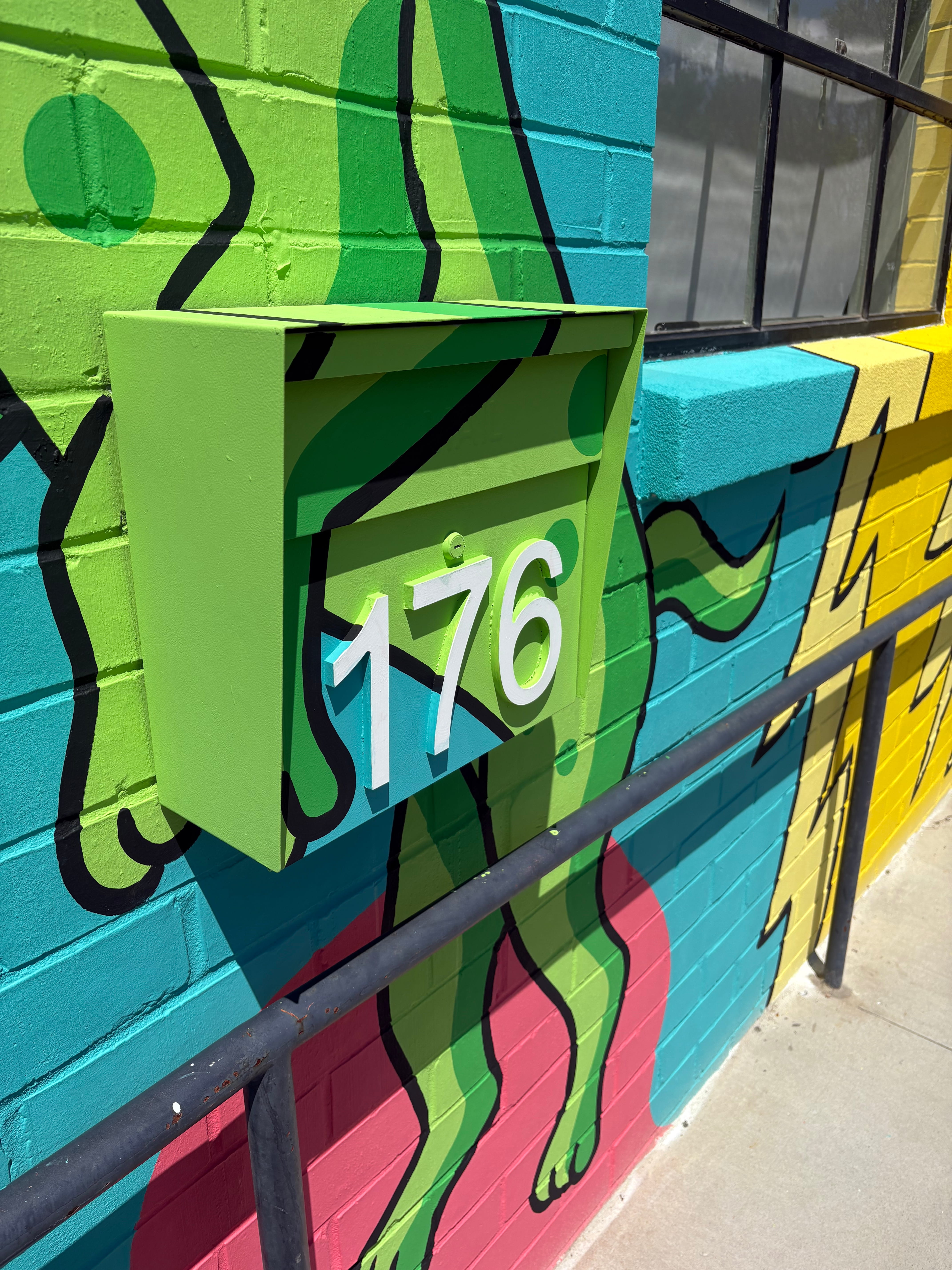 Hand-painted mural detail showing artwork continuing around an exterior wall feature