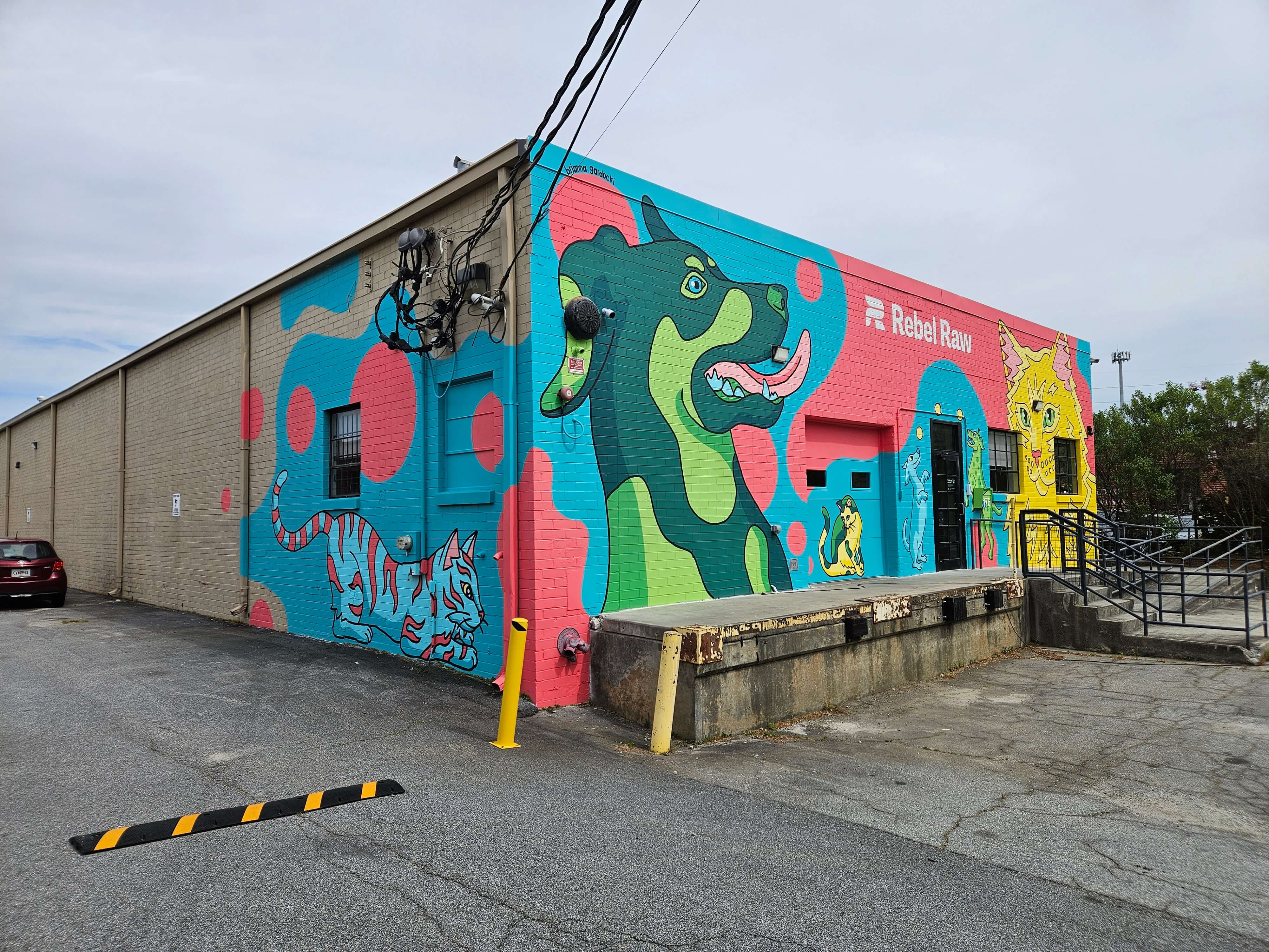 Large custom business mural wrapping around the Rebel Raw building in Atlanta