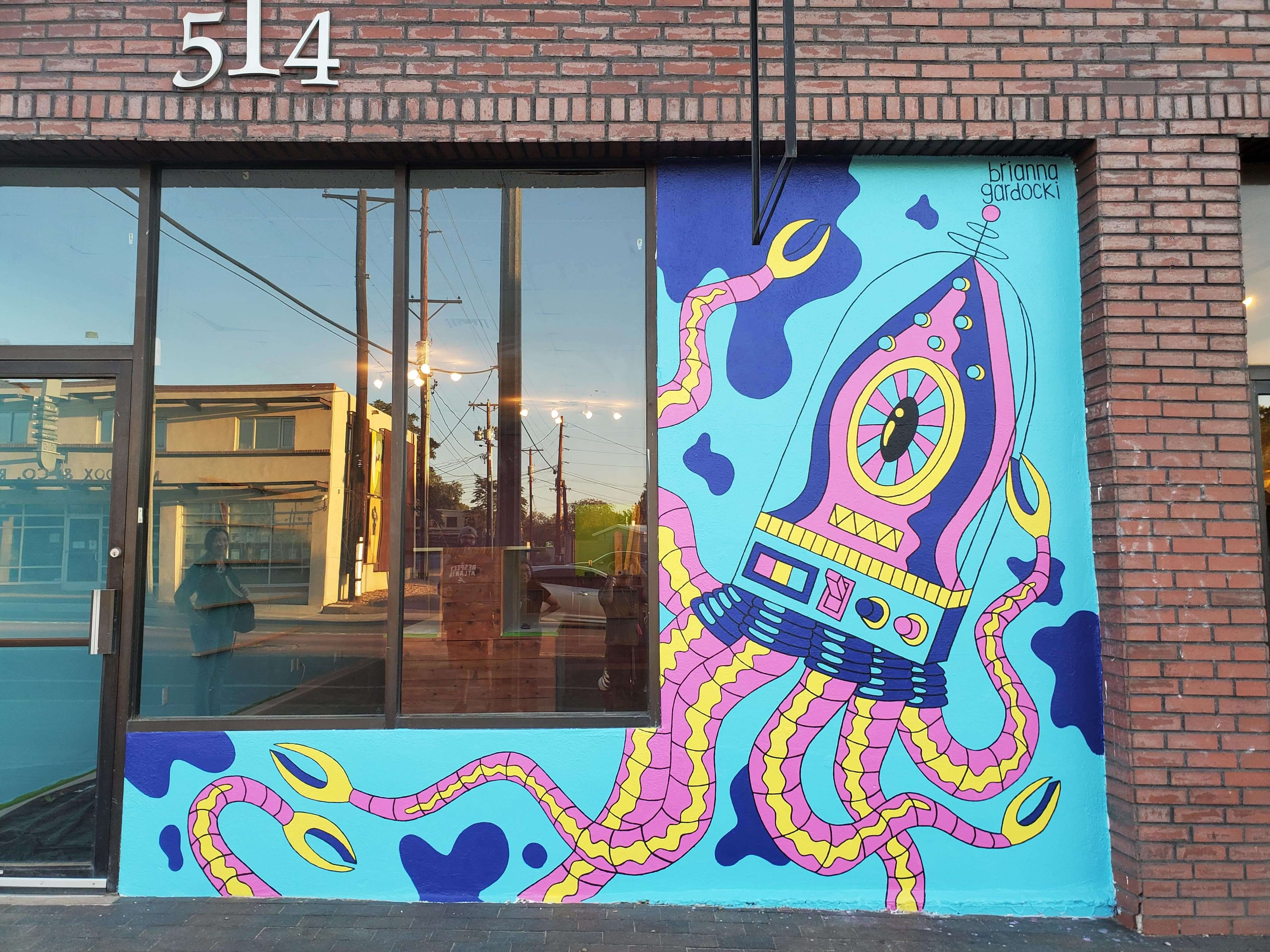 Completed robot squid mural on storefront of Squidly Store, created by Atlanta mural artist