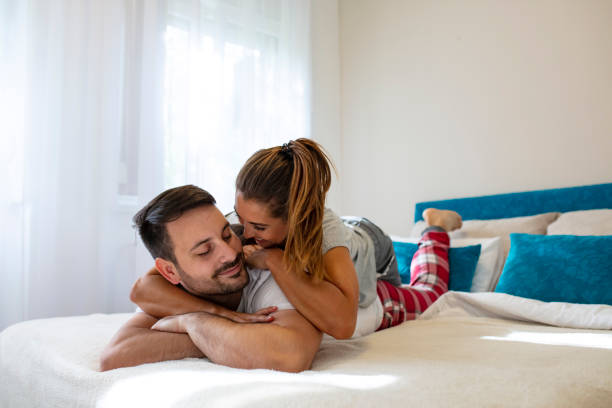Close Up Of Young Couple Lying In Bed Together Stock Photo - Download Image  Now - Adult, Adults Only, Affectionate - iStock