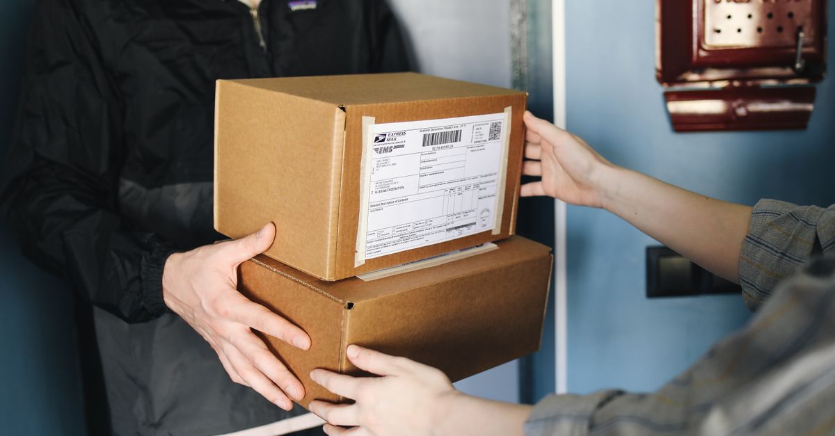 Close-up of hands exchanging cardboard boxes indoors, symbolizing delivery service. — pharmacy