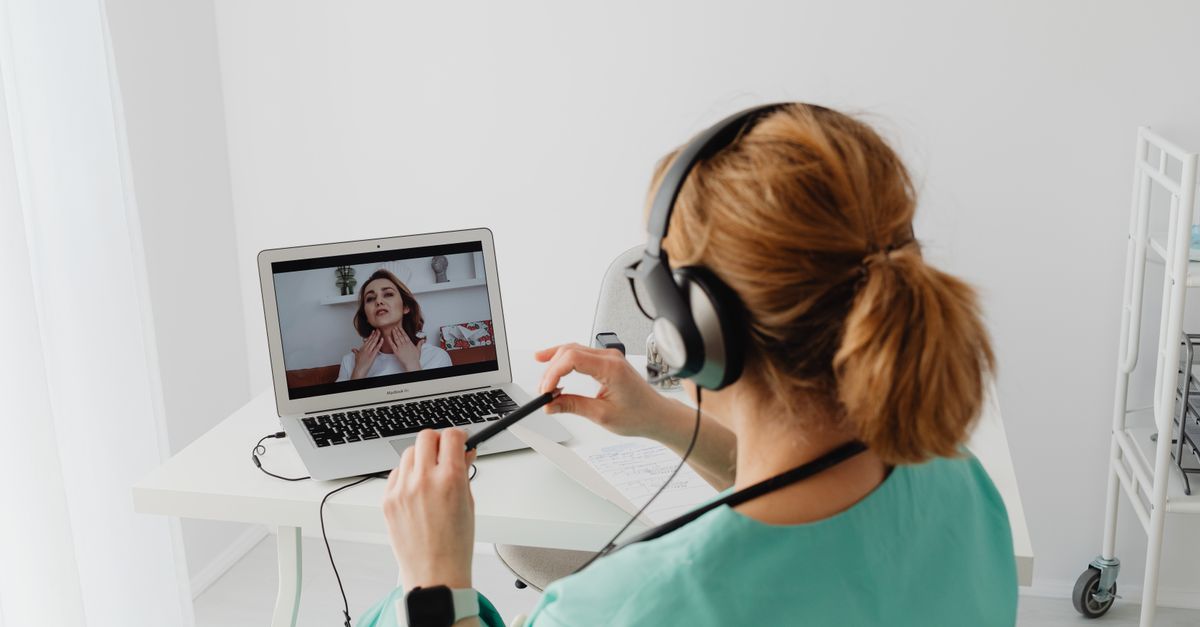 A doctor conducting an online consultation with a patient via laptop in a modern office setting. — quick fix vs full job tele