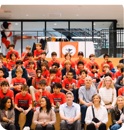 Large group wearing red shirts poses together at indoor event