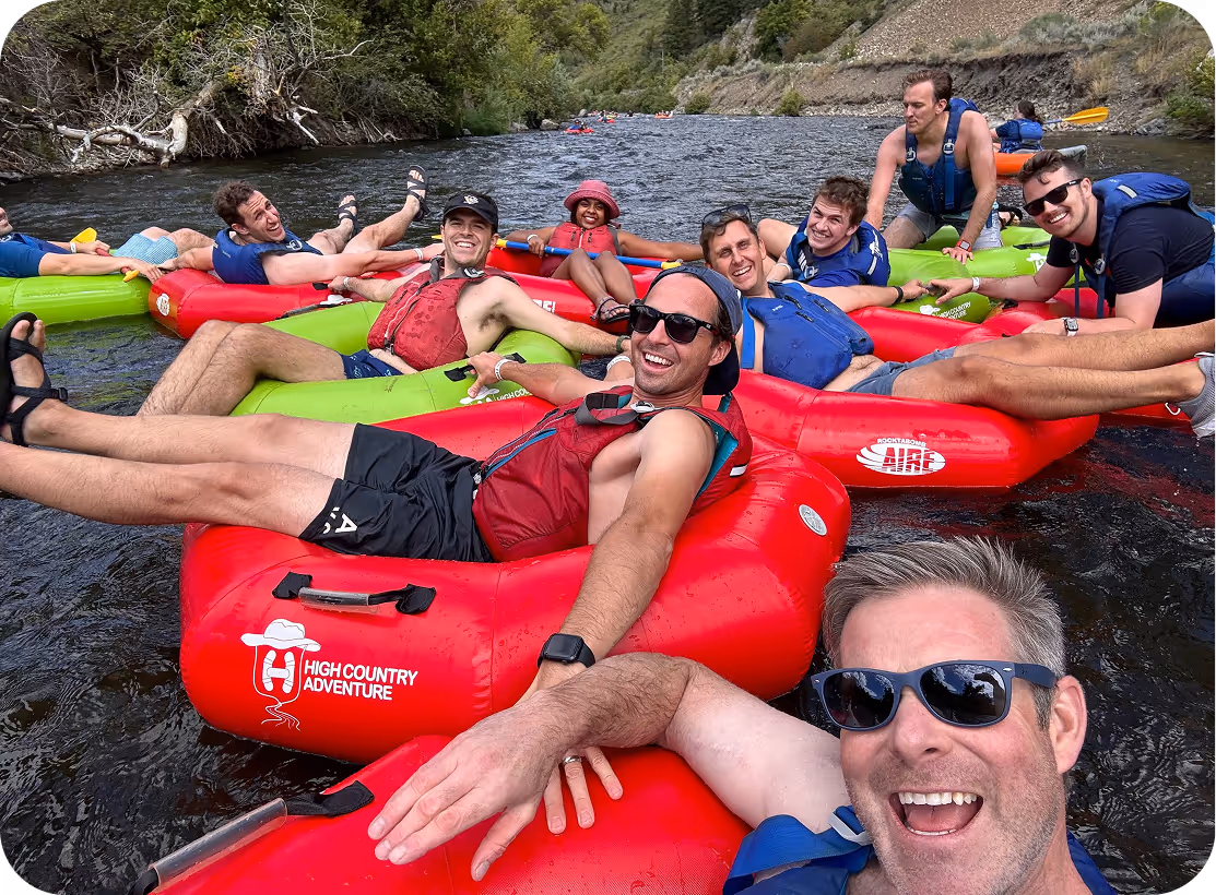 Group river tubing adventure with friends on red and green inflatable tubes