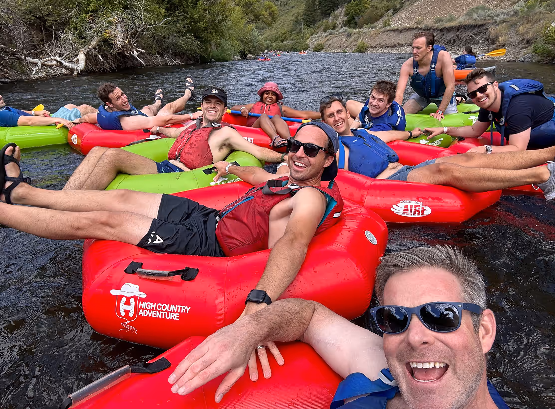Group river tubing adventure with red inflatable tubes in scenic landscape