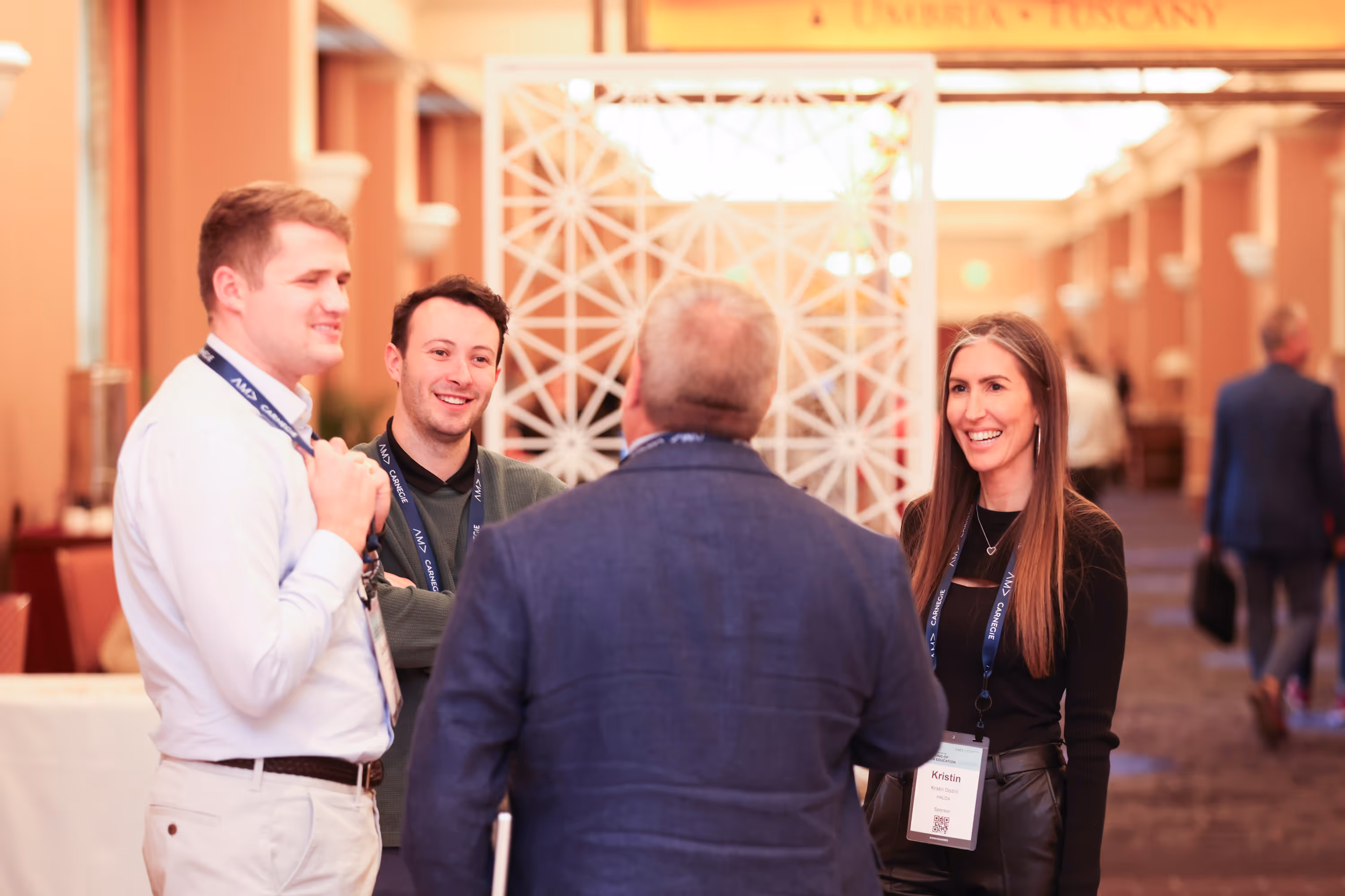 Conference attendees networking and smiling in a bright event space
