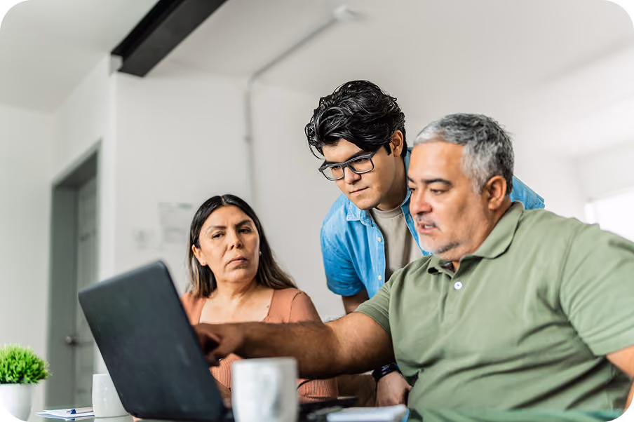 A family researching college applications together on a laptop